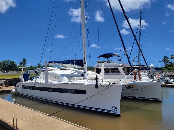 2009 Catana 65 catamaran docked at a marina under a clear blue sky.