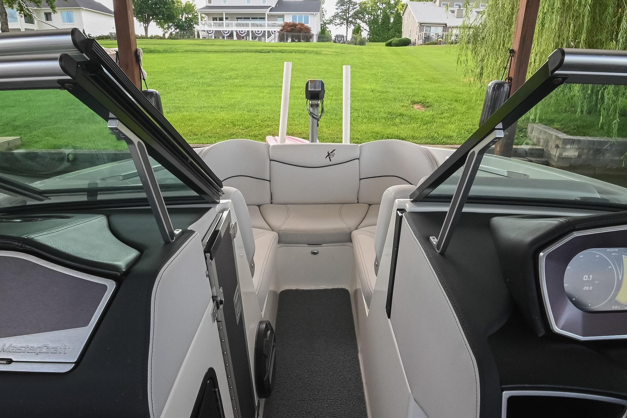 Interior view of 2018 MasterCraft X23 boat with open windshield and plush seating.