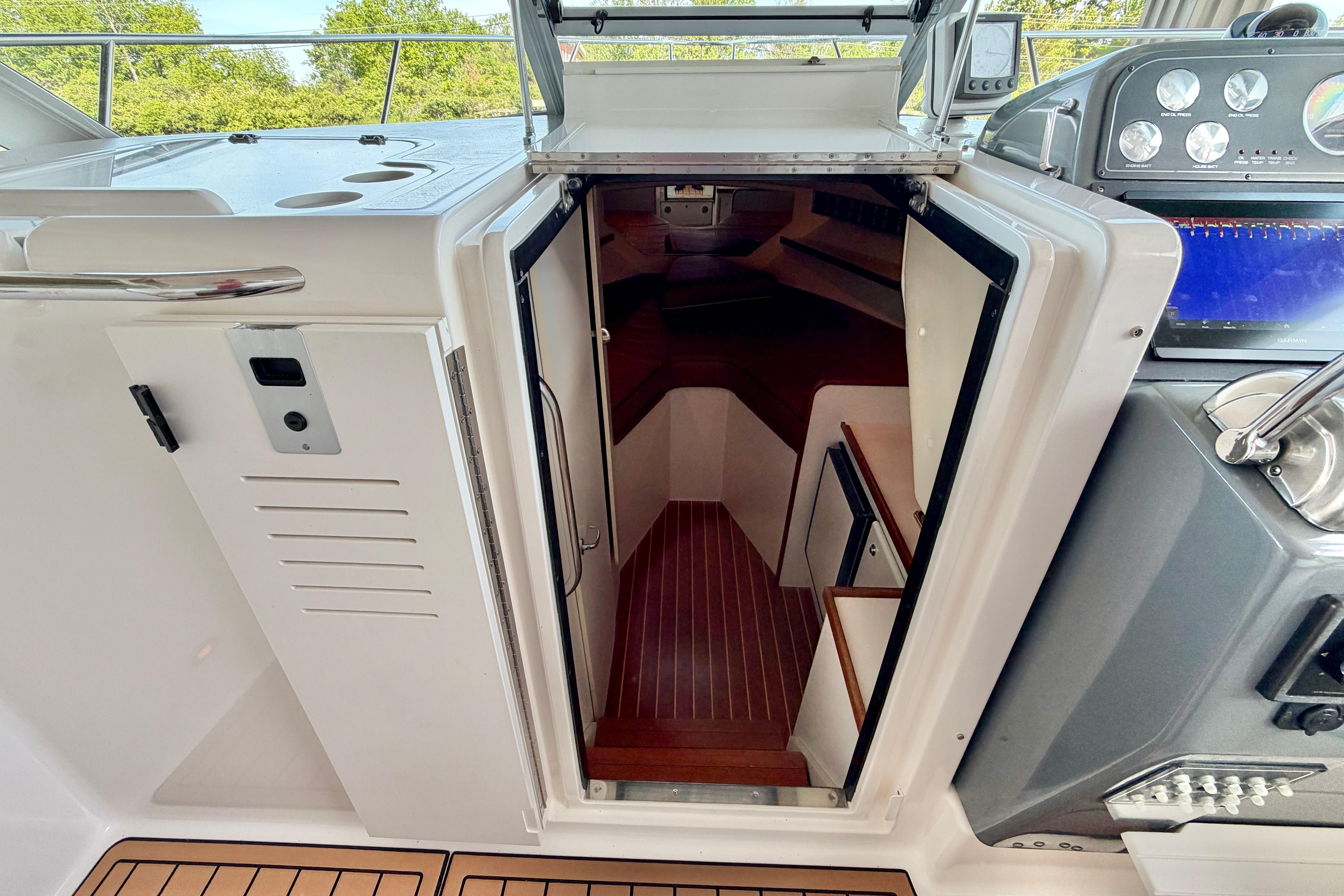 1999 Tiara Yachts 2900 Coronet cabin entrance with wooden flooring and control panel.