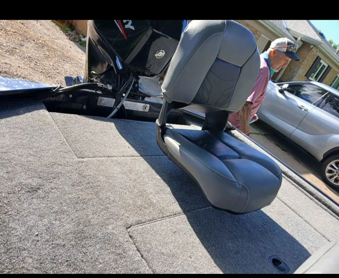 A gray boat seat on a 2024 Bass Tracker 50ELPT, with a man in the background.