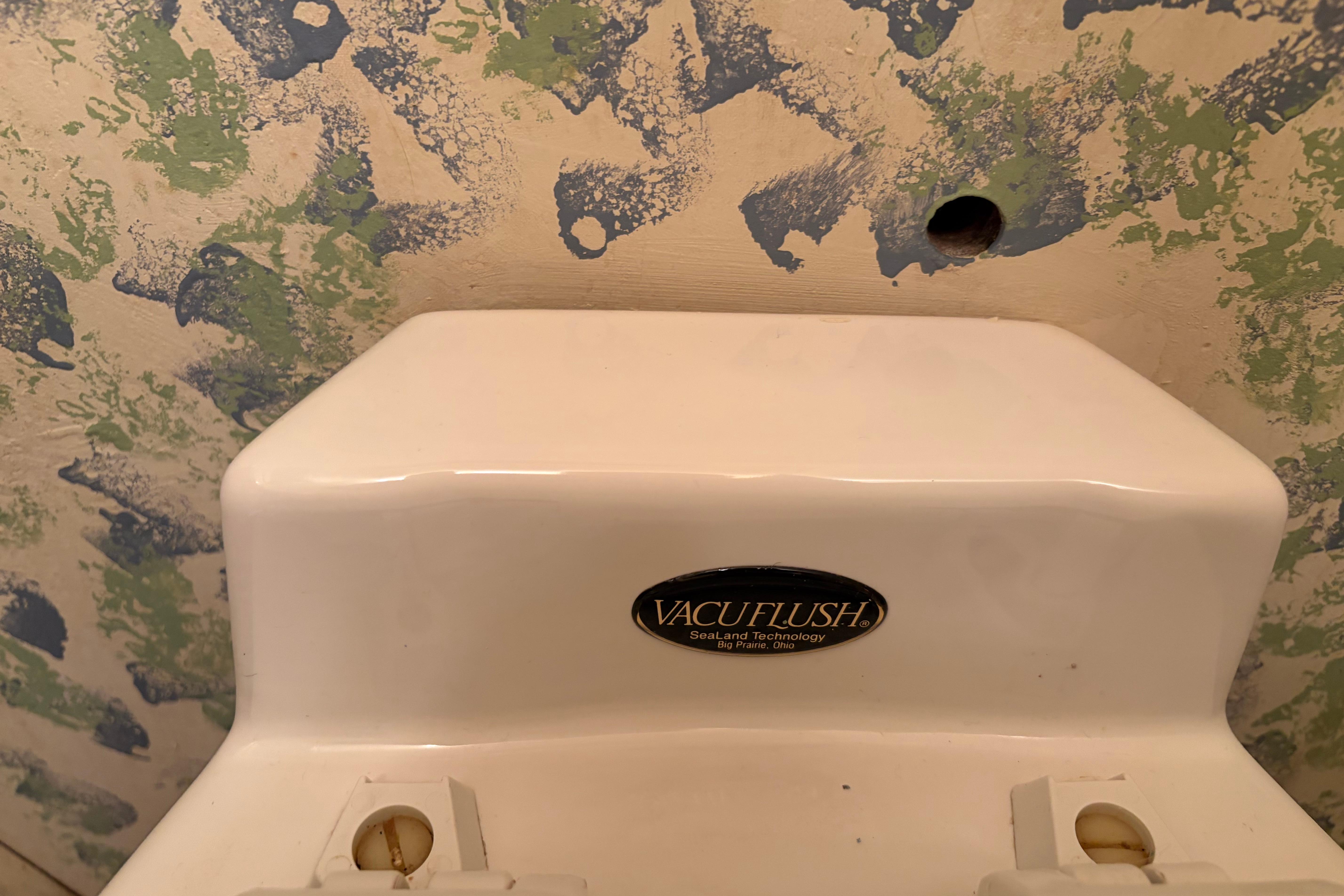 VacuFlush toilet system on 1971 Chris-Craft 42 Commander boat, with textured wall background.