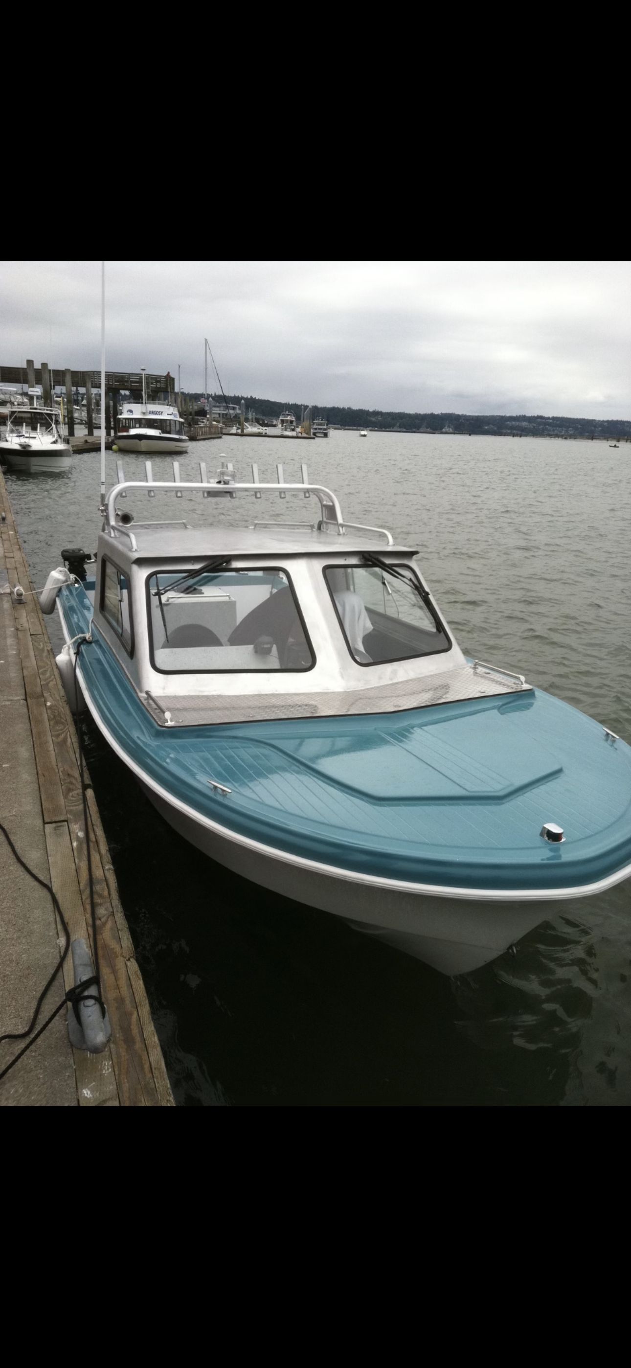 A restored 1967 Fiberform boat docked. It features a blue and white color scheme.