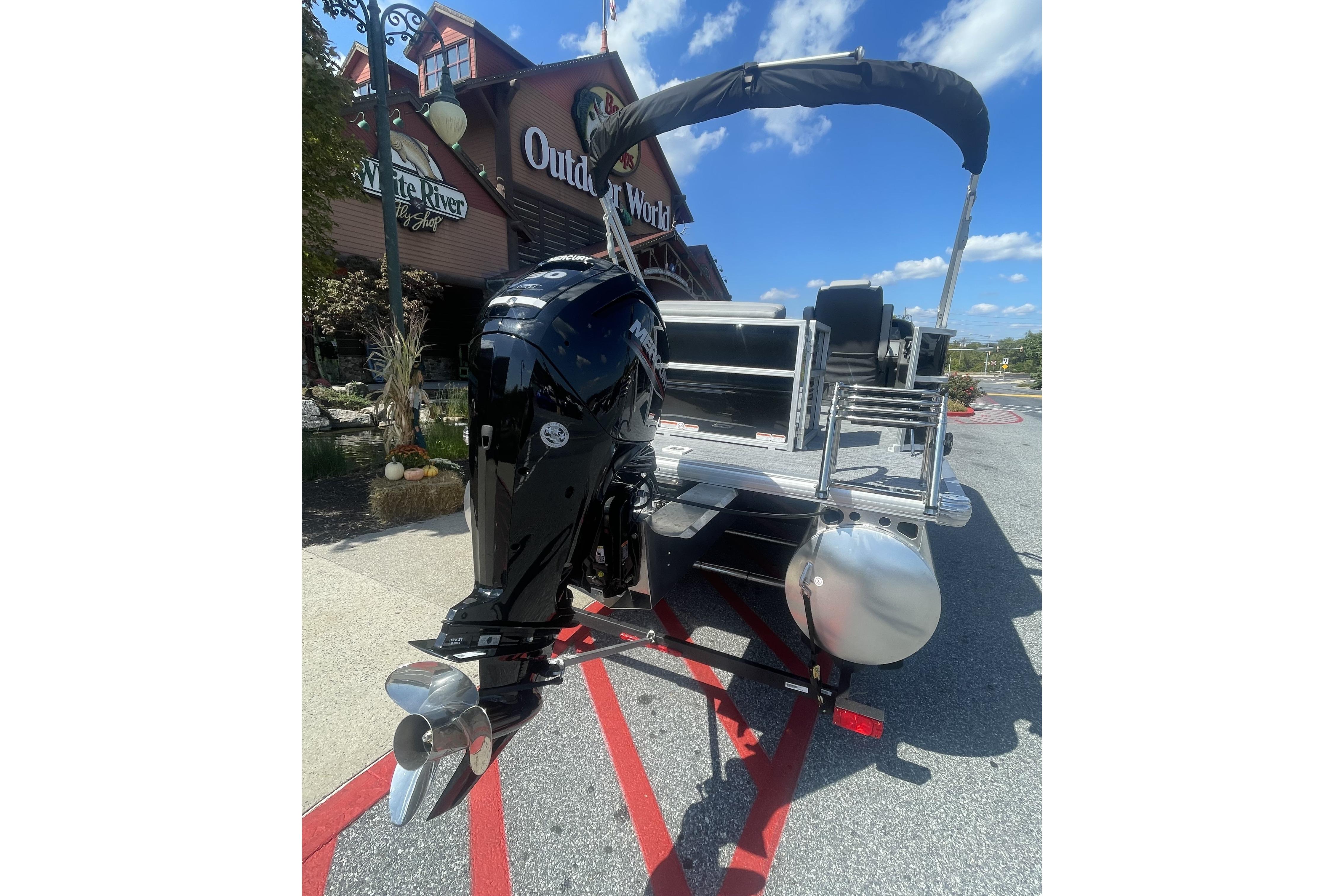 2026 Sun Tracker Party Barge 20 DLX pontoon boat with outboard motor, parked outdoors.