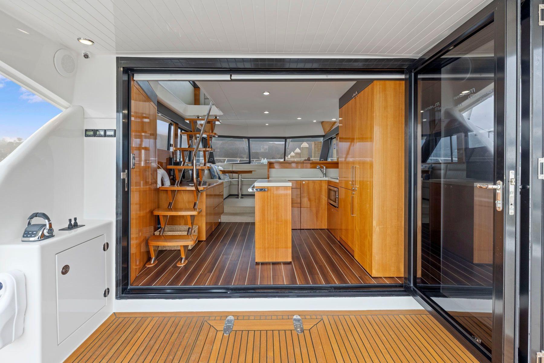 Luxurious interior of 2014 Maritimo M50 yacht with wooden flooring and modern kitchen.