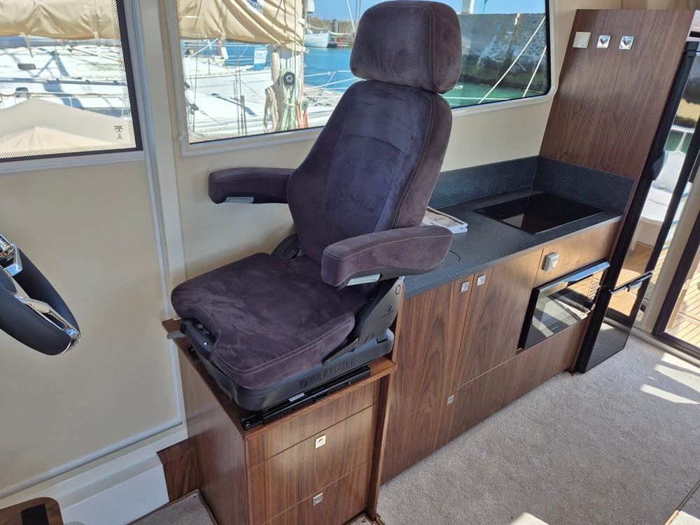 Luxurious interior of 2025 Nord Star 36+ yacht with plush captain's chair and modern kitchenette.