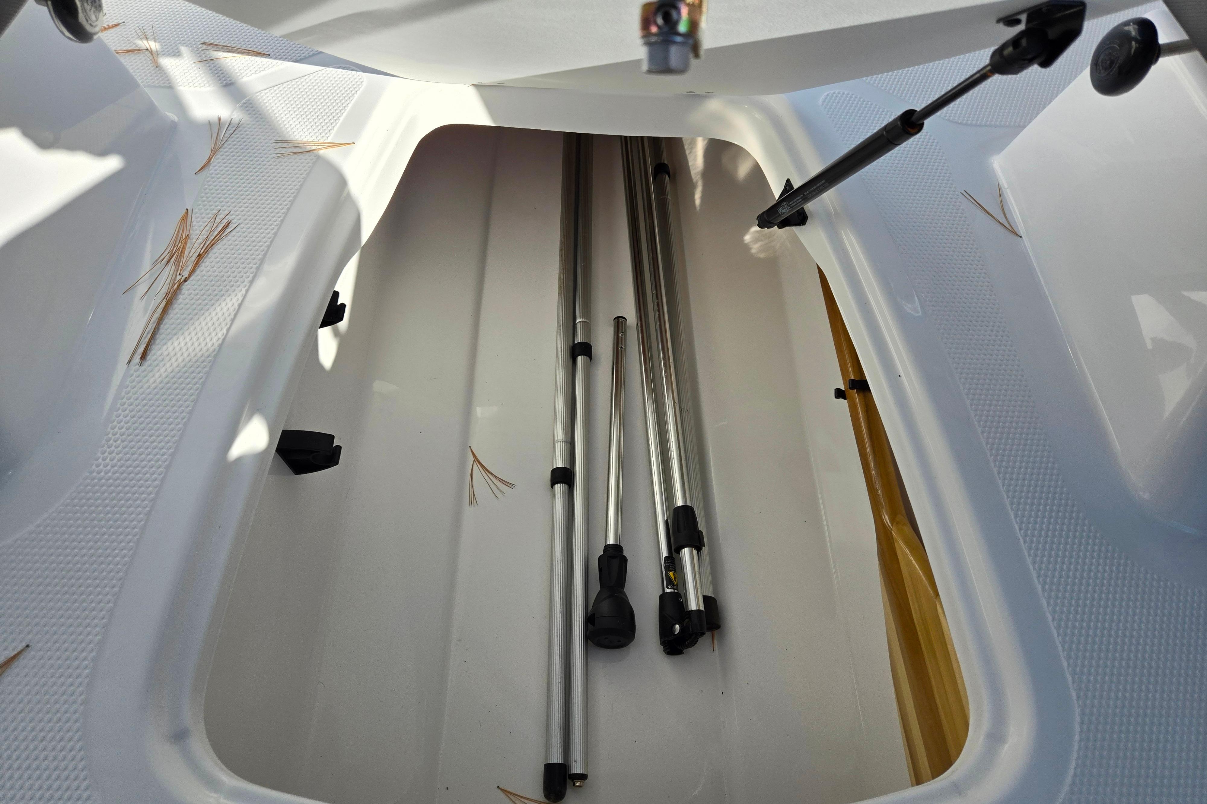 Storage compartment of 2023 Tahoe 185 S boat with metal poles inside.