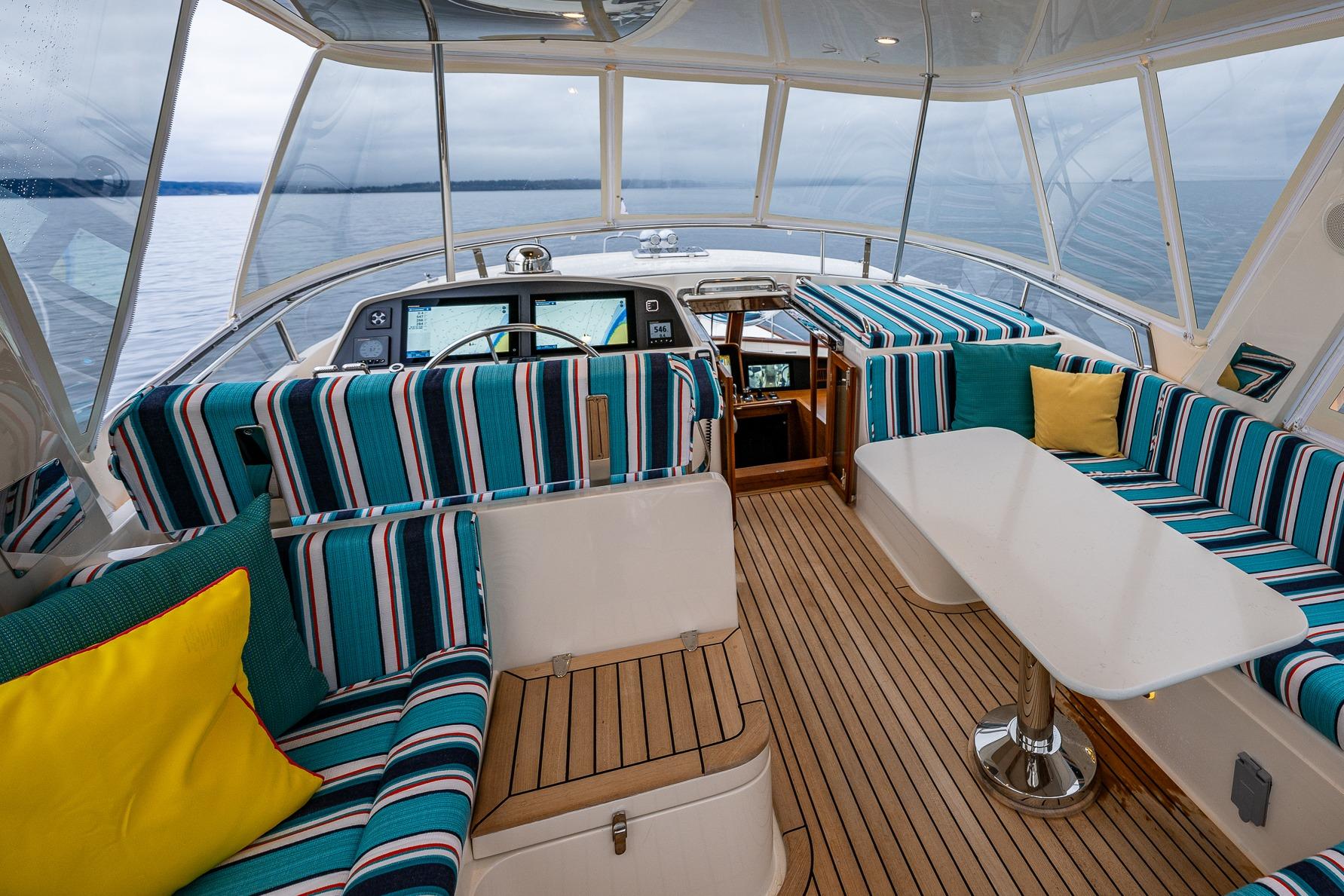 Luxurious 2026 Fleming 55 Pilothouse interior with striped seating and ocean view.