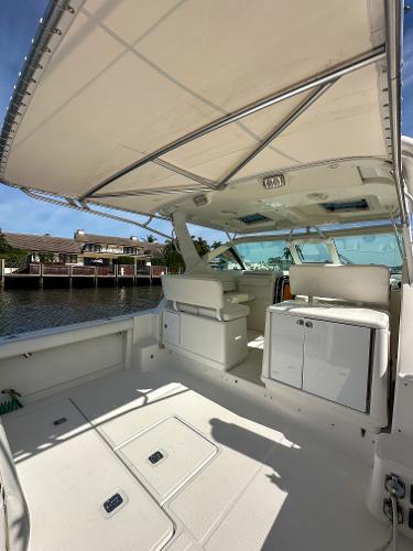 2006 Tiara Yachts 3200 Open boat interior with seating and canopy, docked by waterfront homes.