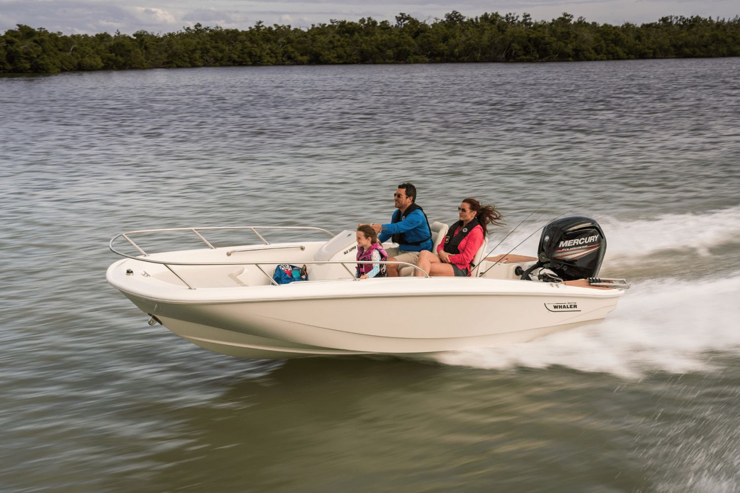 A Boston Whaler 160 Super Sport speeds across the water with three people on board.