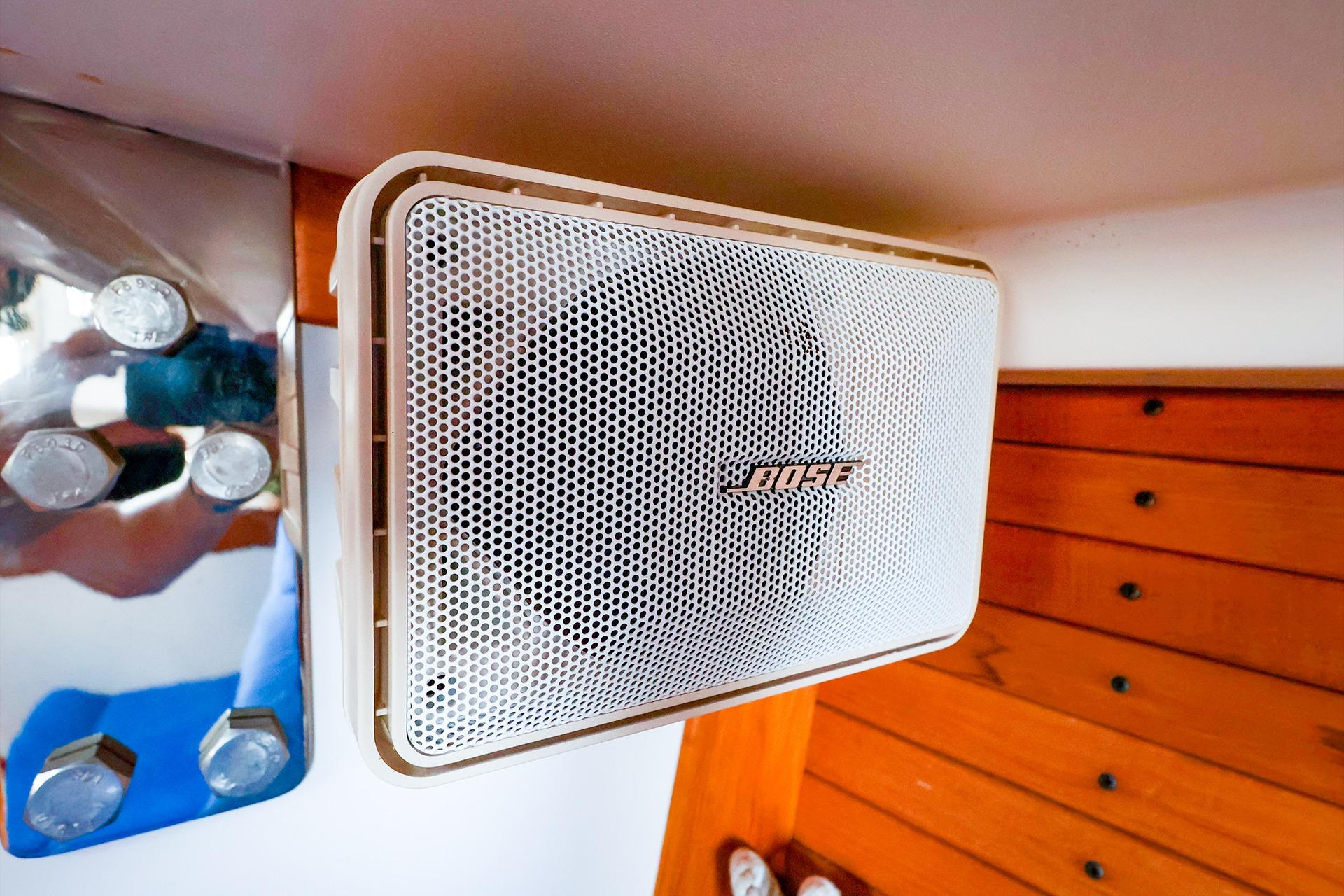 Bose speaker mounted on a 2001 J Boats J/32, with wooden paneling and metal bolts.