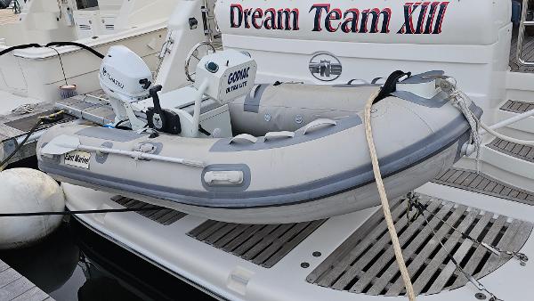 Inflatable dinghy on Neptunus 56 Flybridge yacht, 2005 model, docked with "Dream Team XIII" signage.