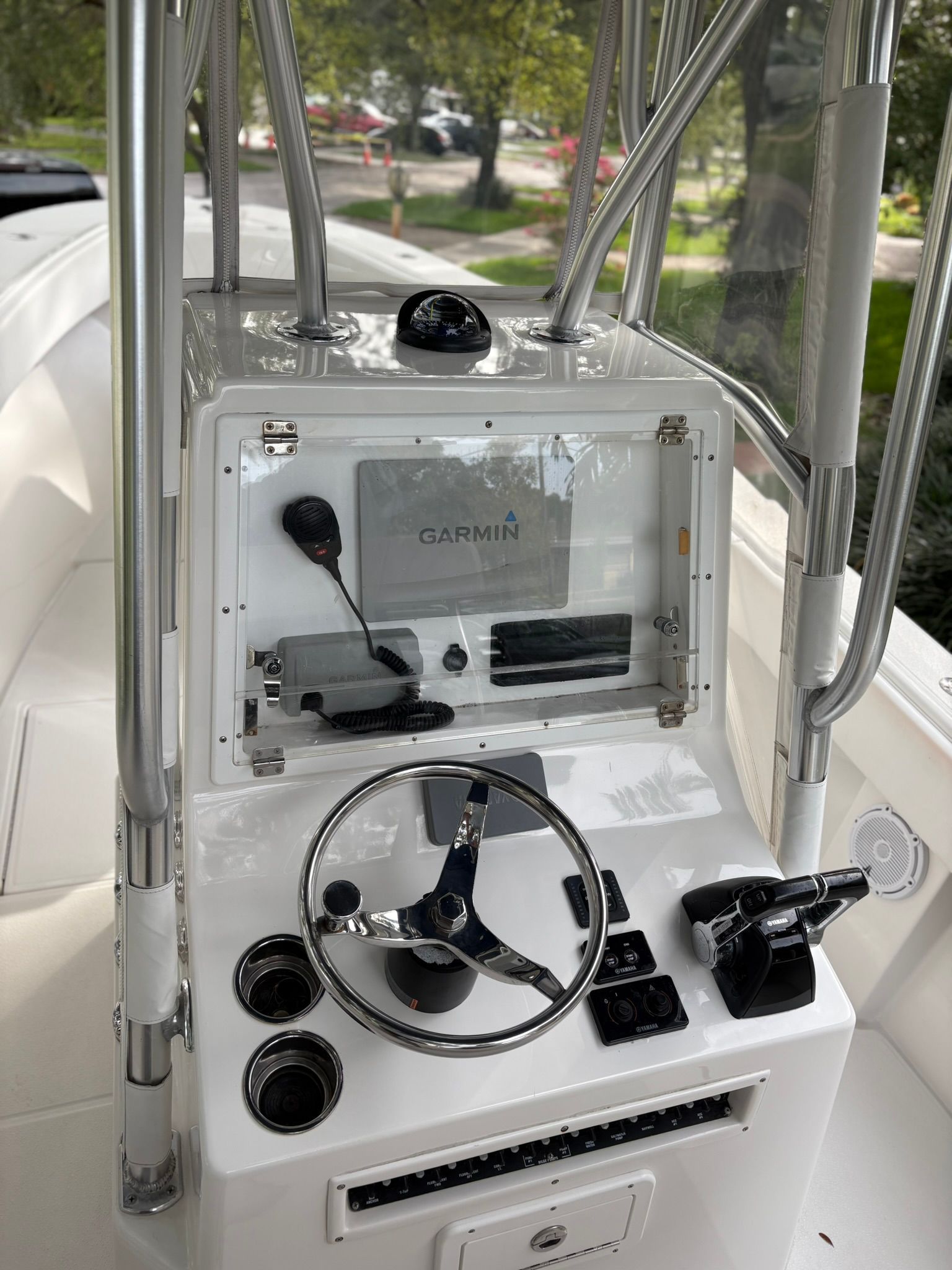 The cockpit of a white boat with a Garmin navigation system and control elements.