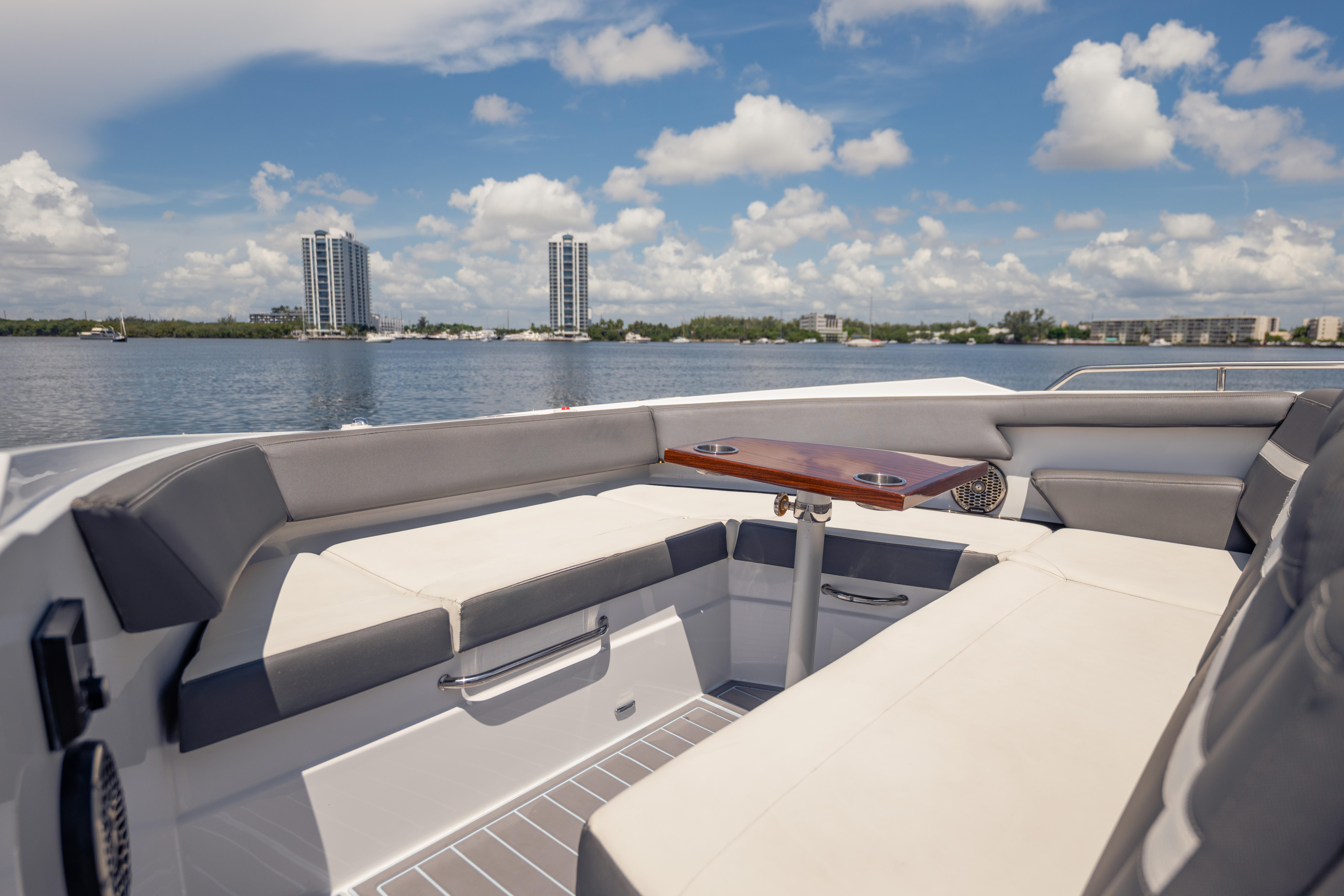 Luxurious seating area on 2021 Cruisers Yachts 38 GLS, overlooking serene waterfront skyline.