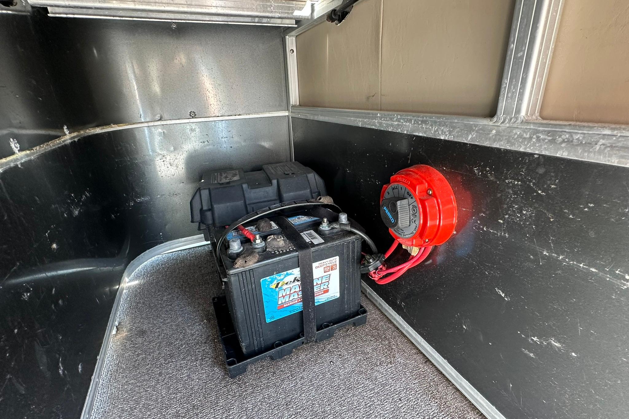 Battery compartment of a 2016 SUNTRACKER Party Barge 20 with wiring and switch.