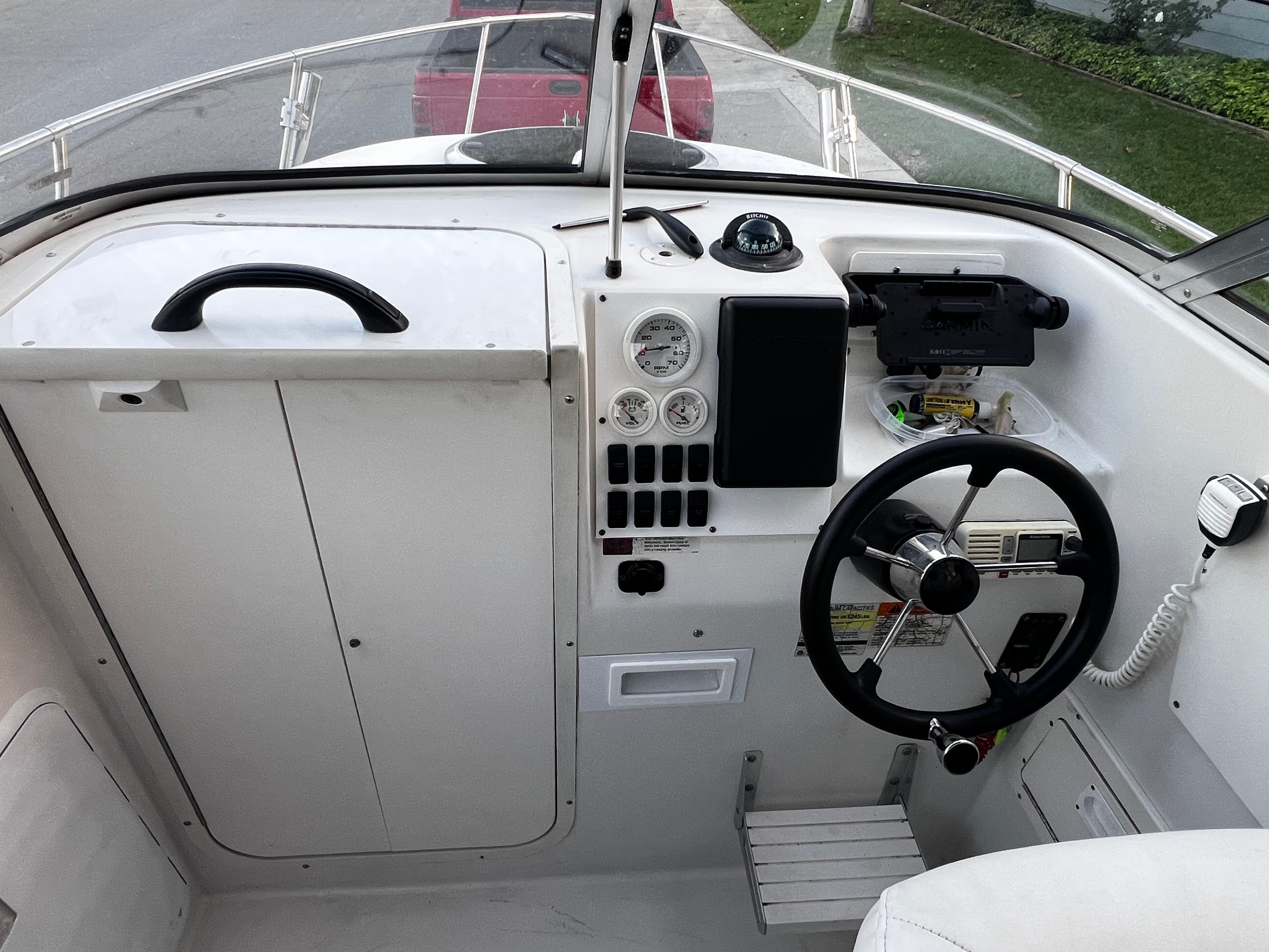 The cockpit of a 2001 Seaswirl Striper 1851 WA with steering wheel, gauges, and radio.