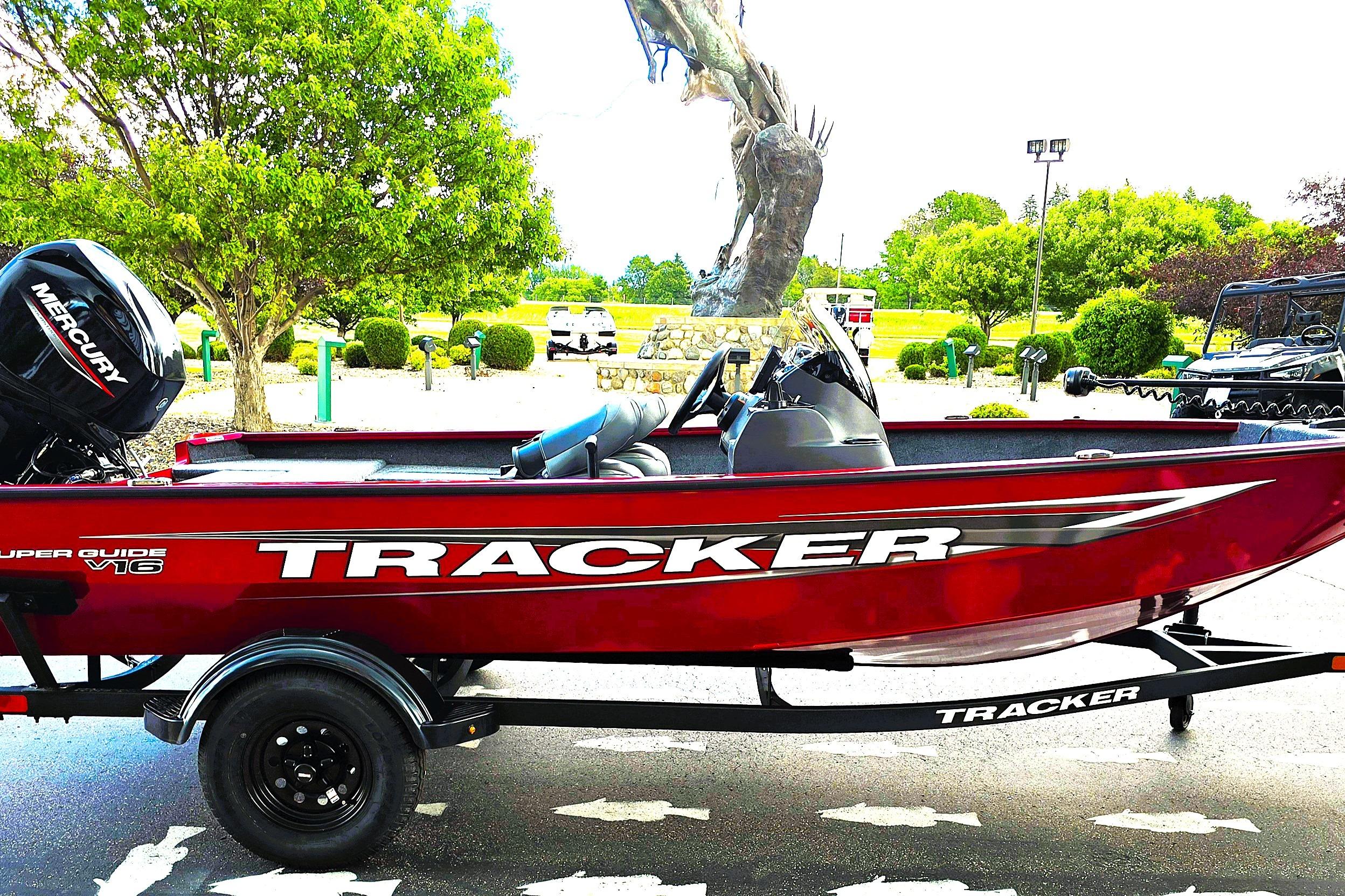 2026 Tracker Super Guide V-16 SC boat with Mercury engine, parked outdoors.