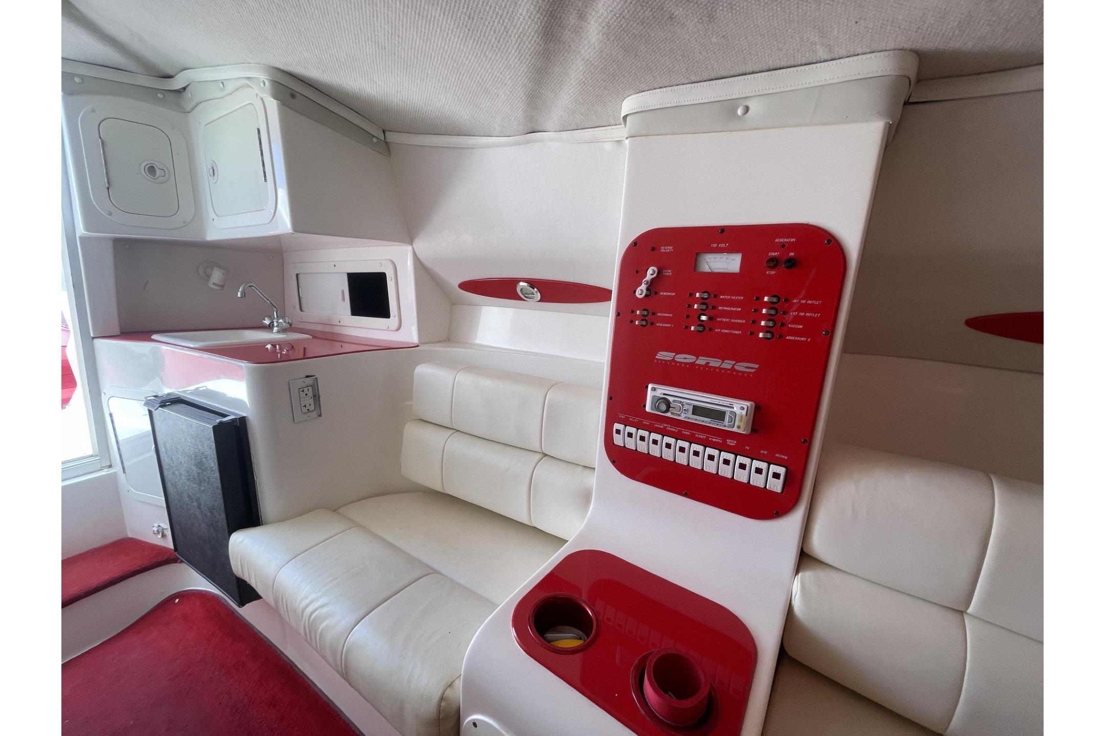 Interior of a 2006 Sonic 386 boat featuring a control panel, seating, and kitchenette.