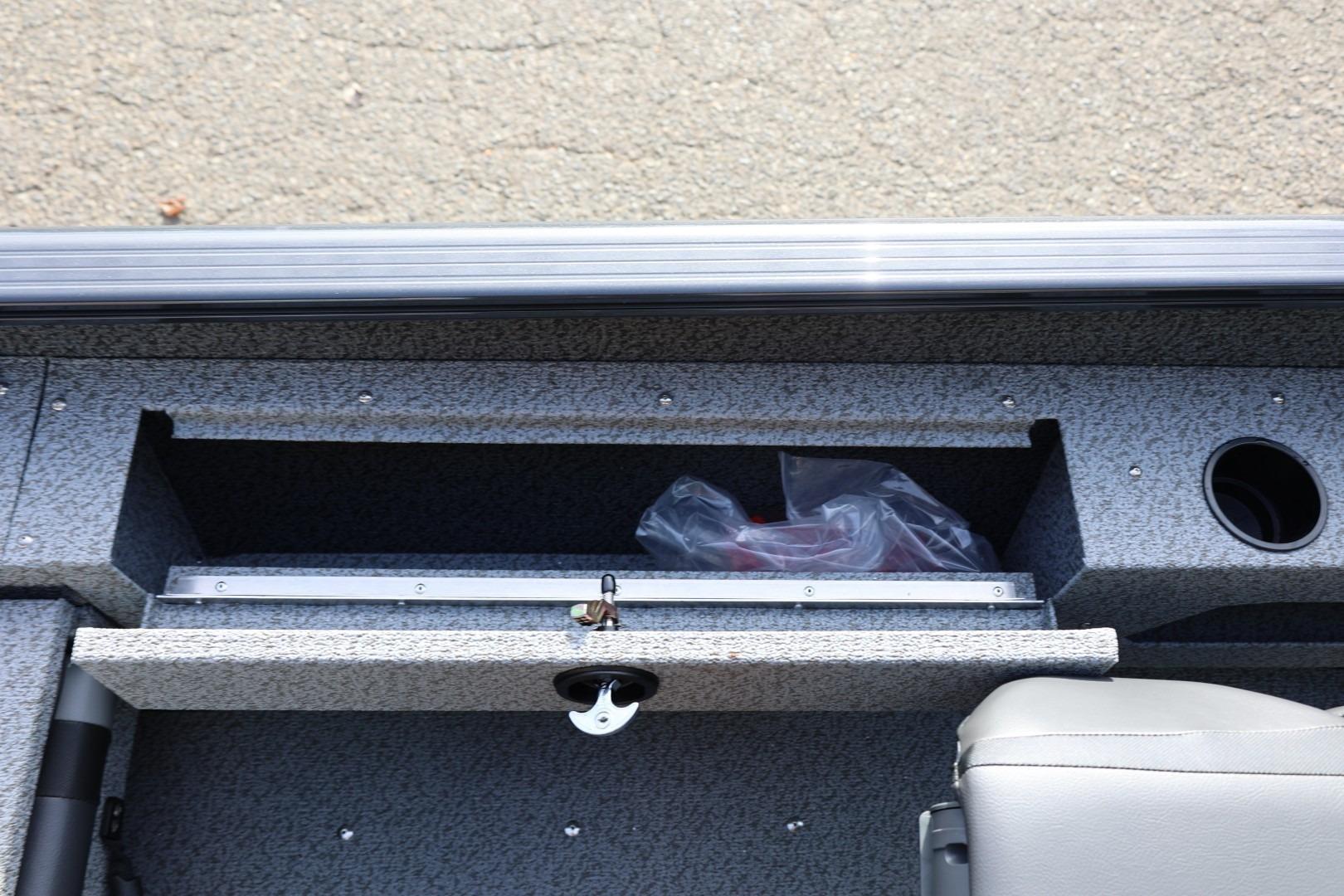 2026 Lund 1675 Adventure Sport boat interior storage compartment with seat and cup holder.