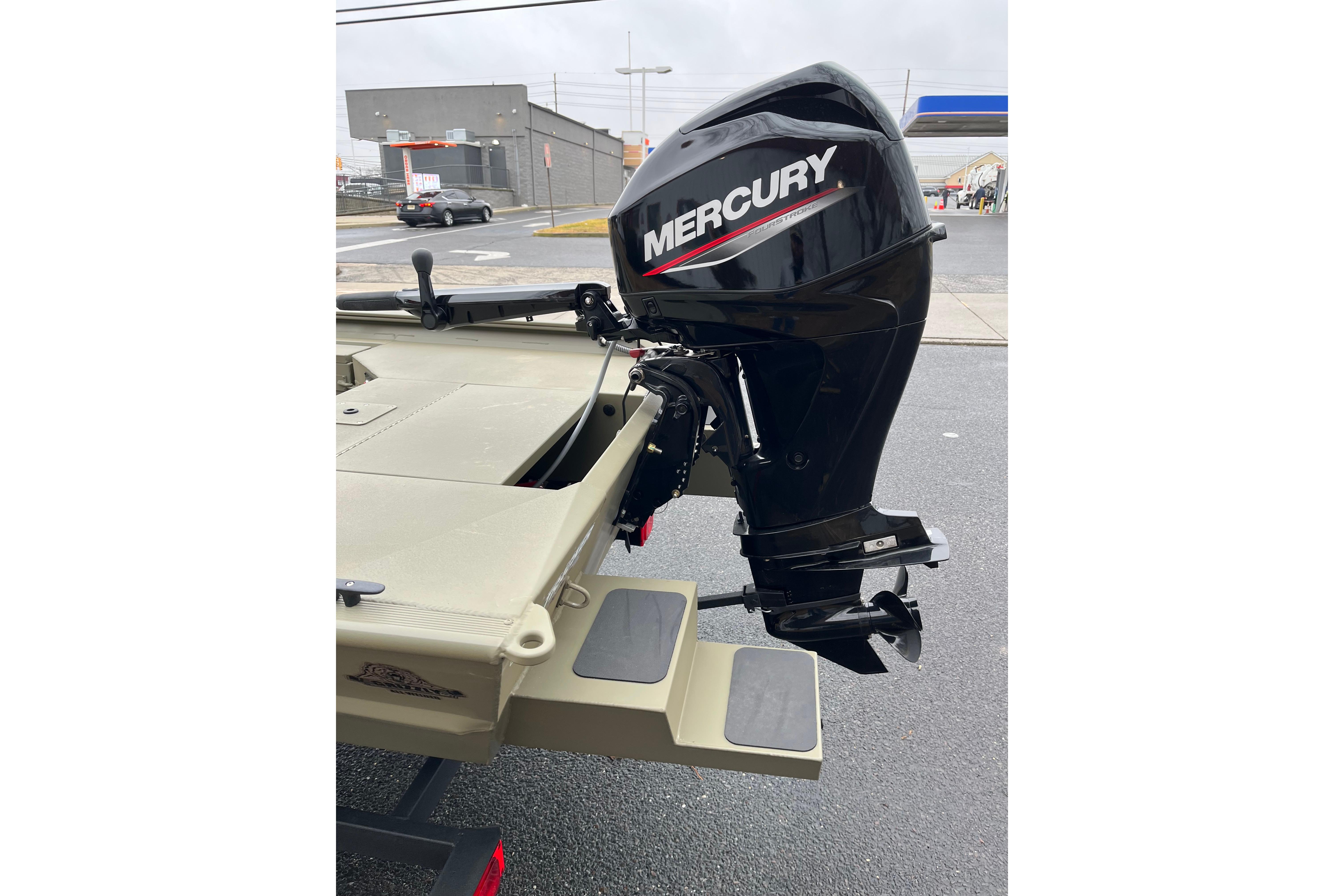2026 Tracker Grizzly 1654 T Sportsman boat with Mercury outboard motor, parked outdoors.