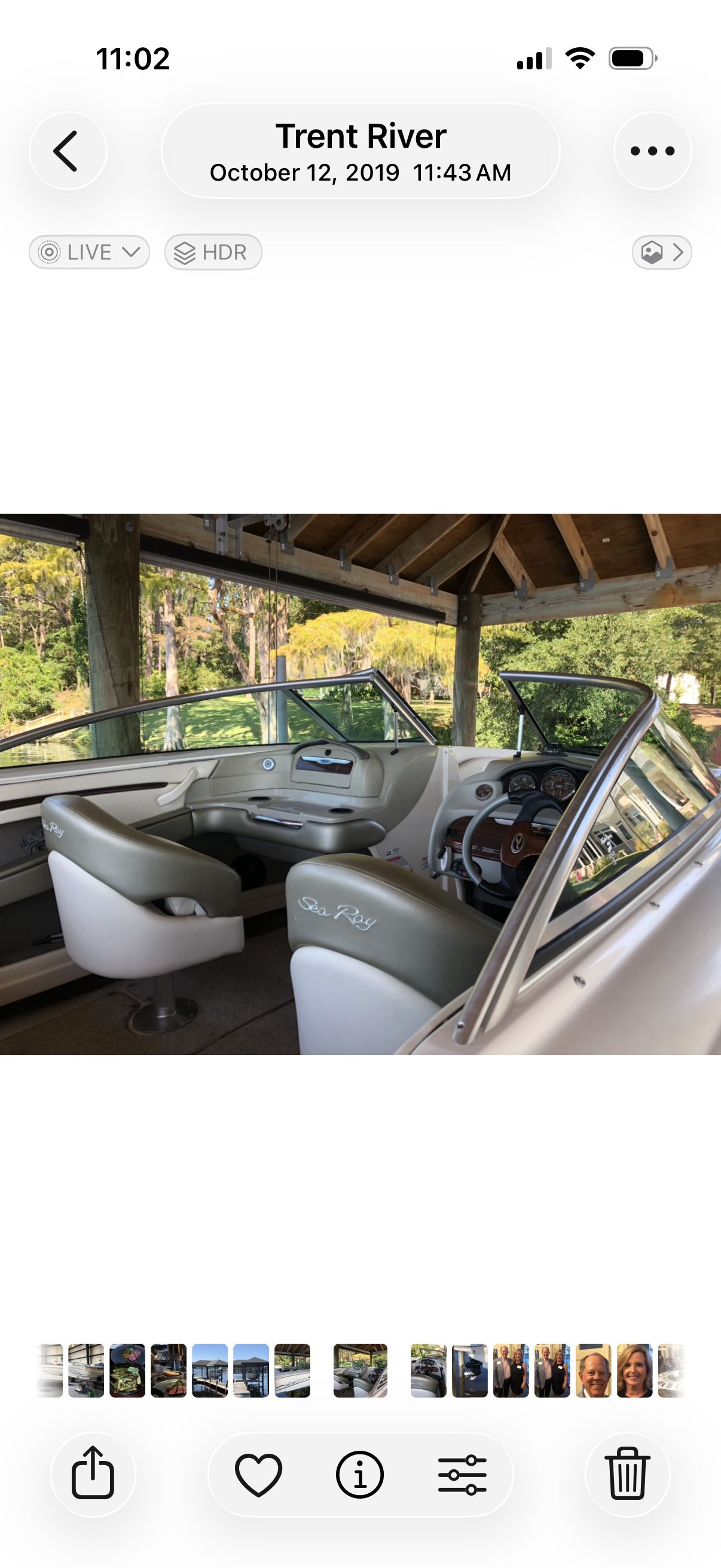 The image shows the cockpit of a 2004 Sea Ray 220 Select boat. It's parked under a covered area, with a clear view of the steering wheel and seats.