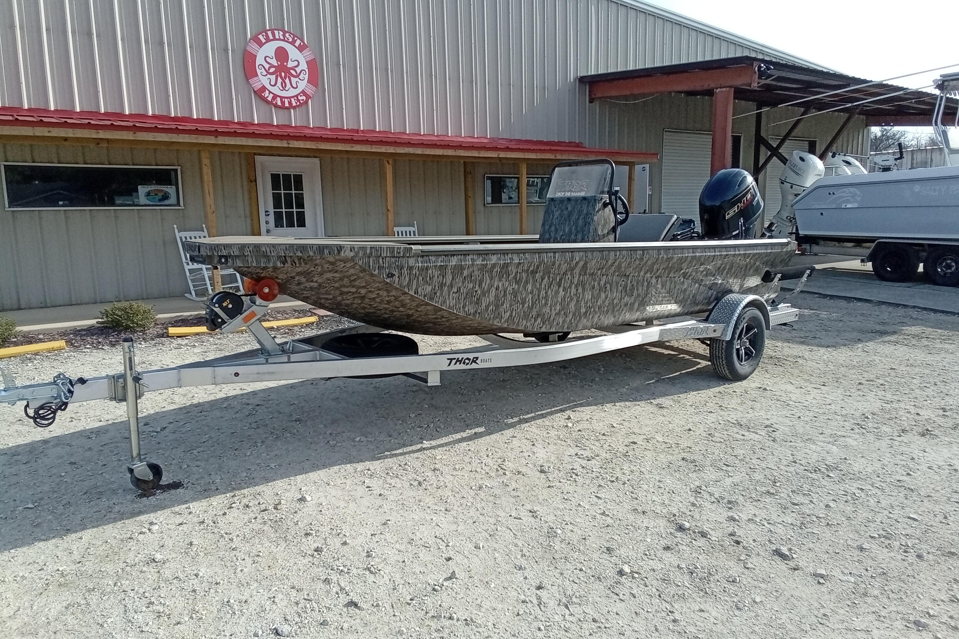 2026 Thor 1900 Low Country Elite boat on trailer outside a building.