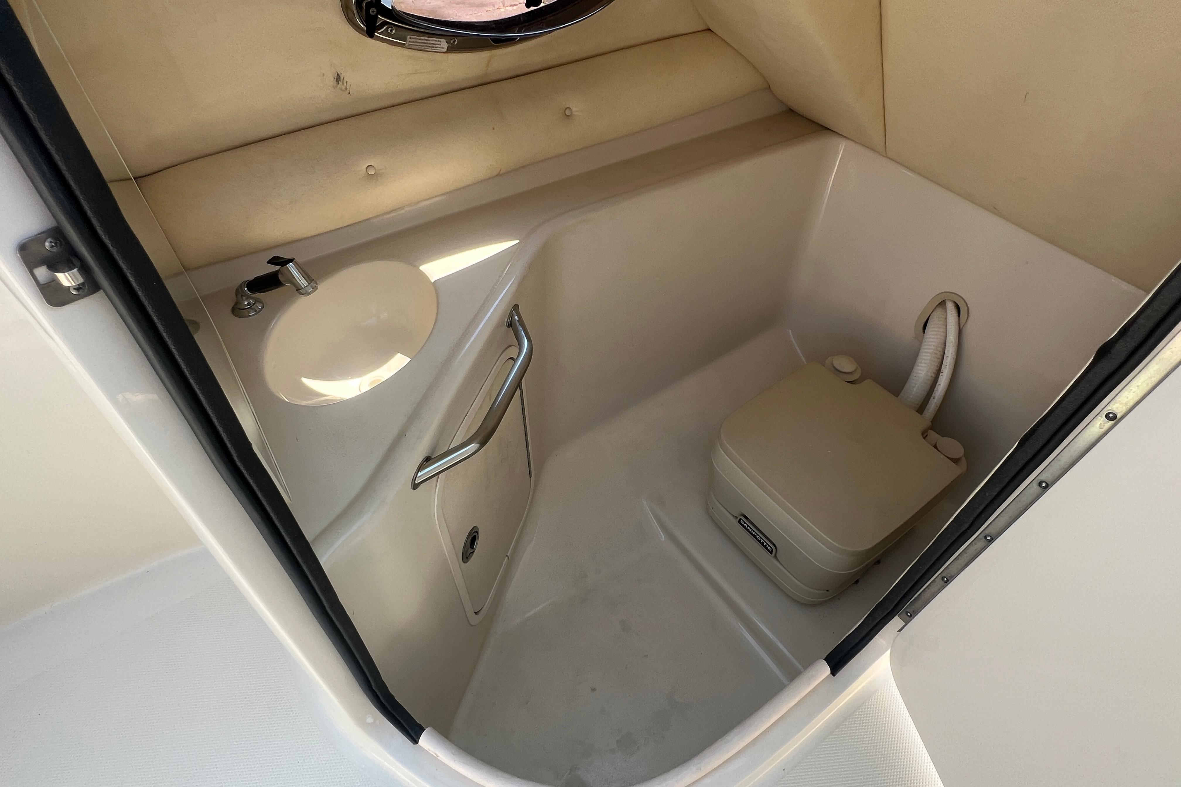 2005 Sea Ray 240 Sundeck interior with compact marine toilet and sink.