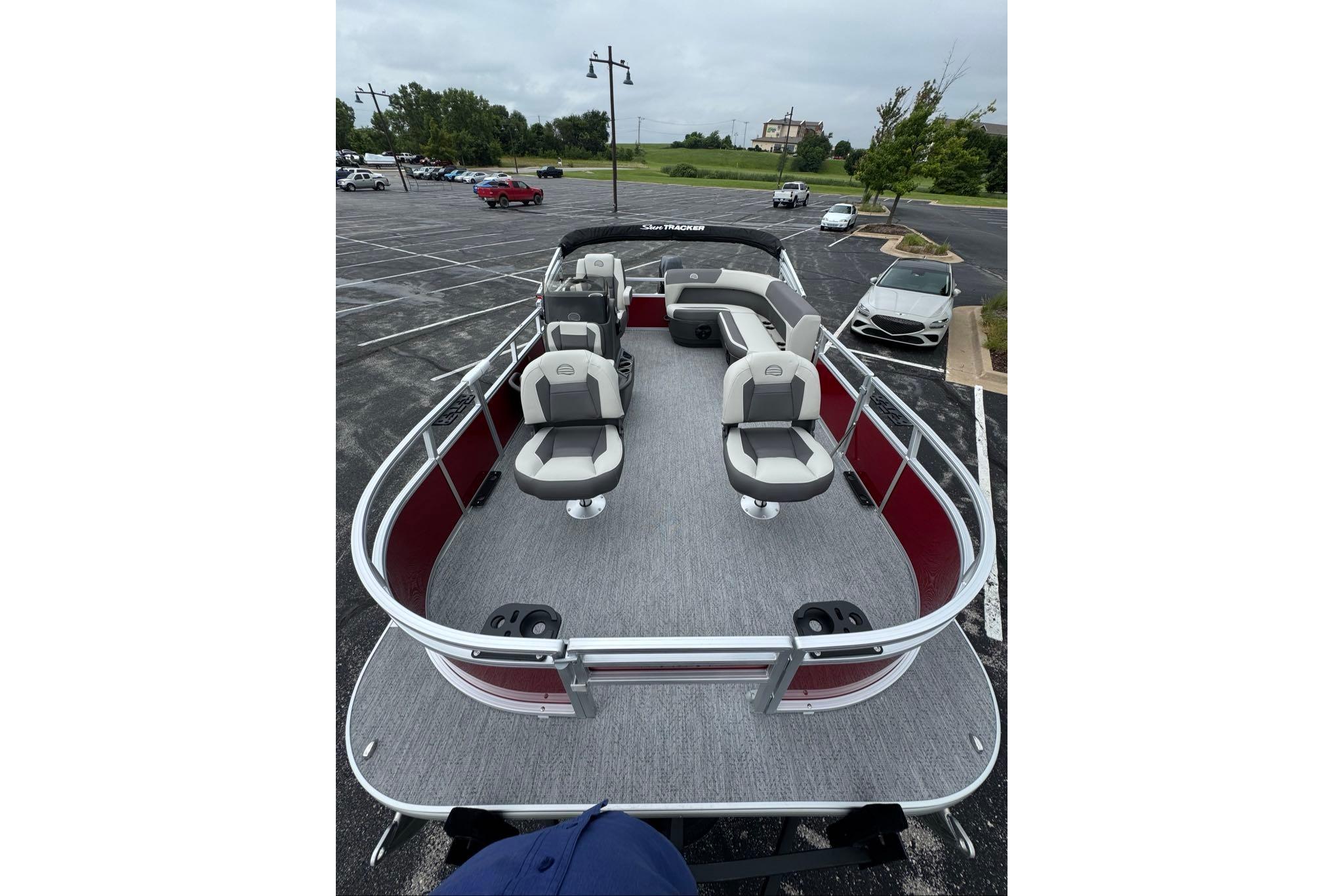 2026 Sun Tracker Bass Buggy 16 XL Select pontoon boat in parking lot.
