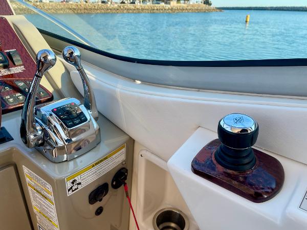 Helm controls of 2014 Sea Ray 330 Sundancer with throttle and joystick, overlooking water.
