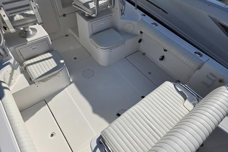 2004 Robalo R235 Walkaround boat interior with white seating and storage compartments.