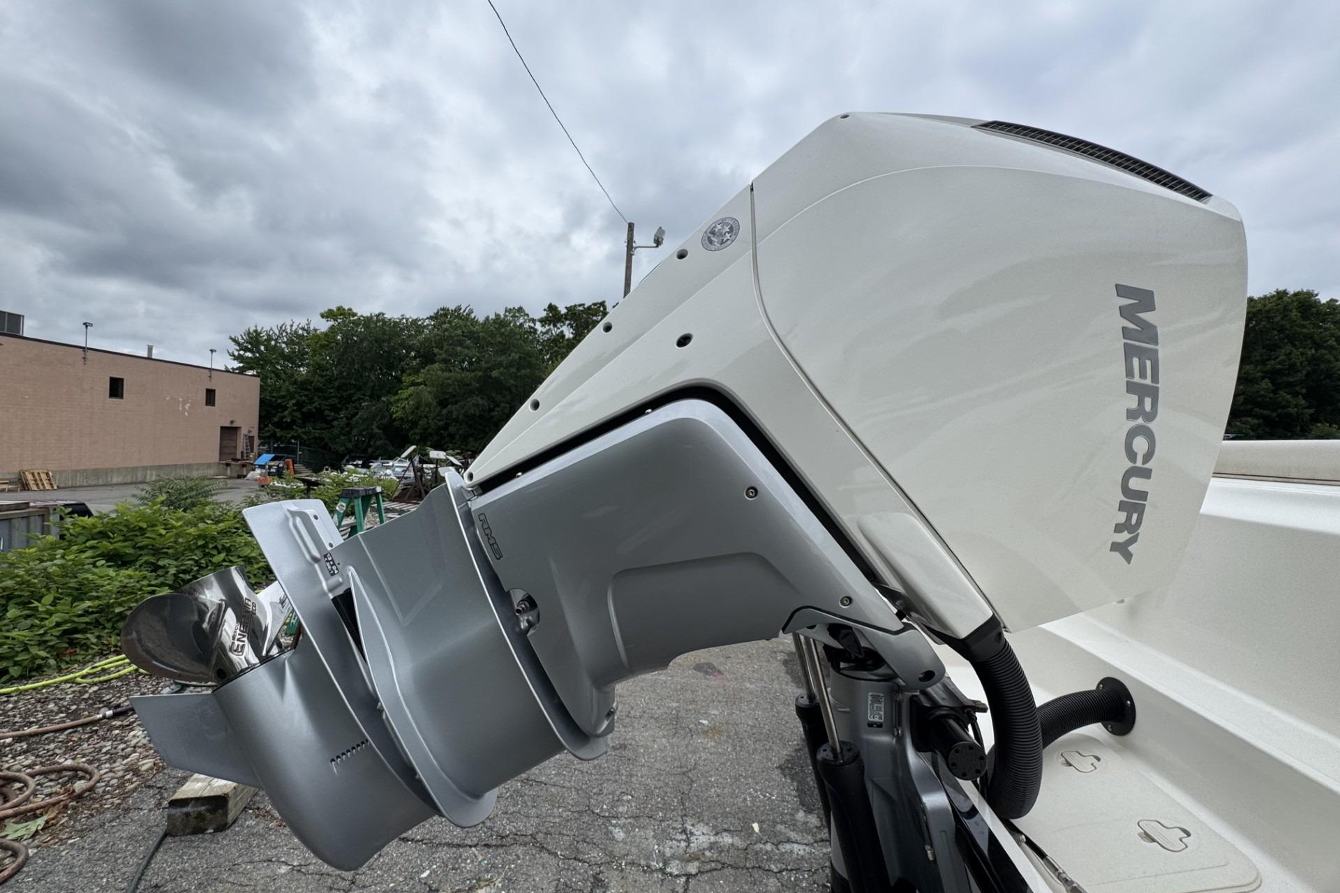 2024 Boston Whaler 230 Outrage with Mercury outboard motor, parked outdoors.