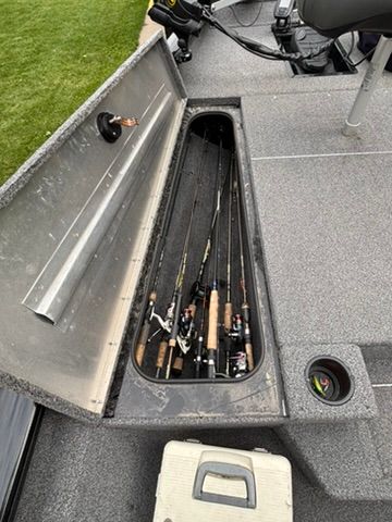 Fishing rods stored in a compartment on a Bass Tracker boat.