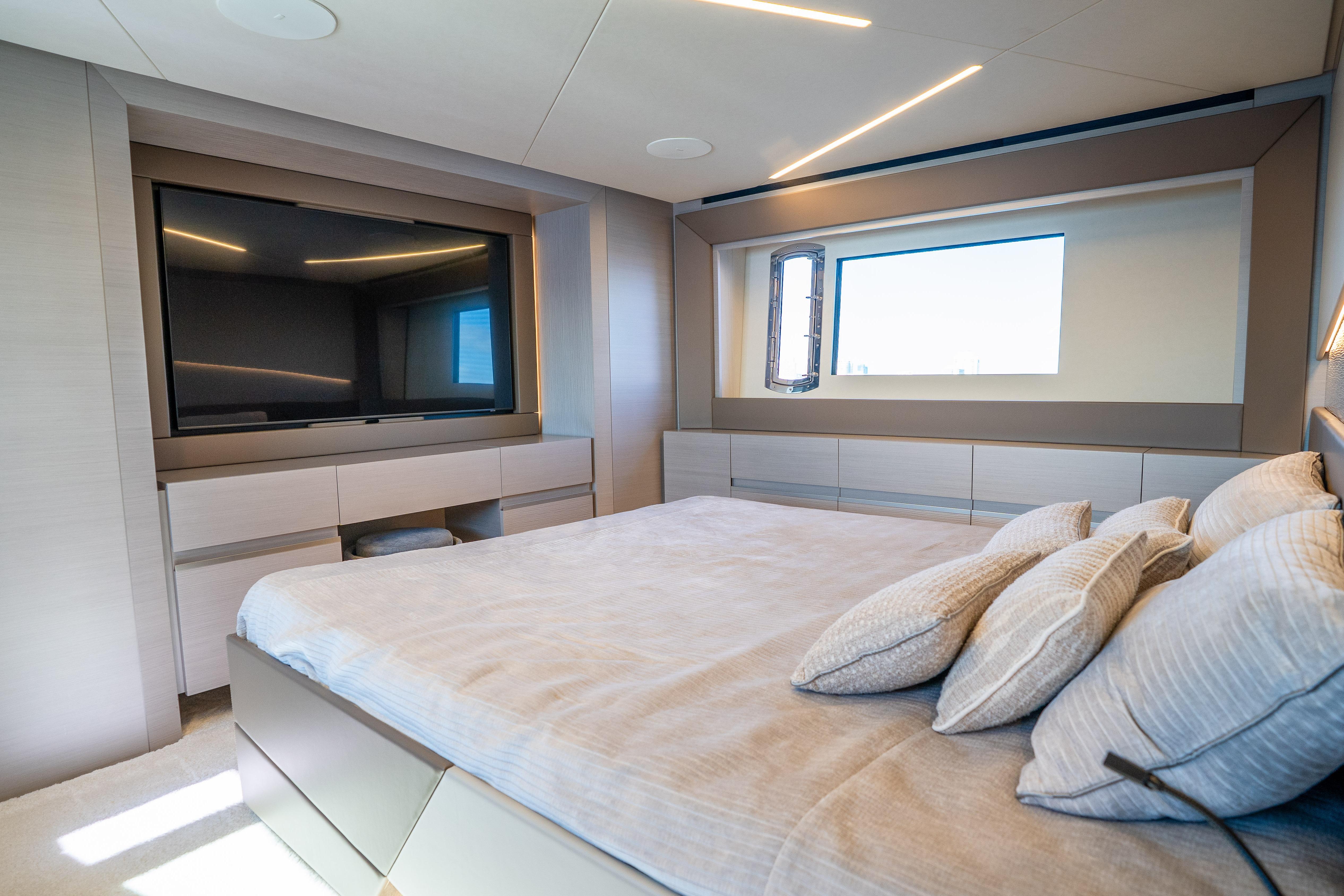 Luxurious bedroom interior of 2024 Pershing 7X yacht with modern design and large TV.