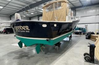 1964 Striker Model 120 boat in a garage, featuring a dark hull and green keel.