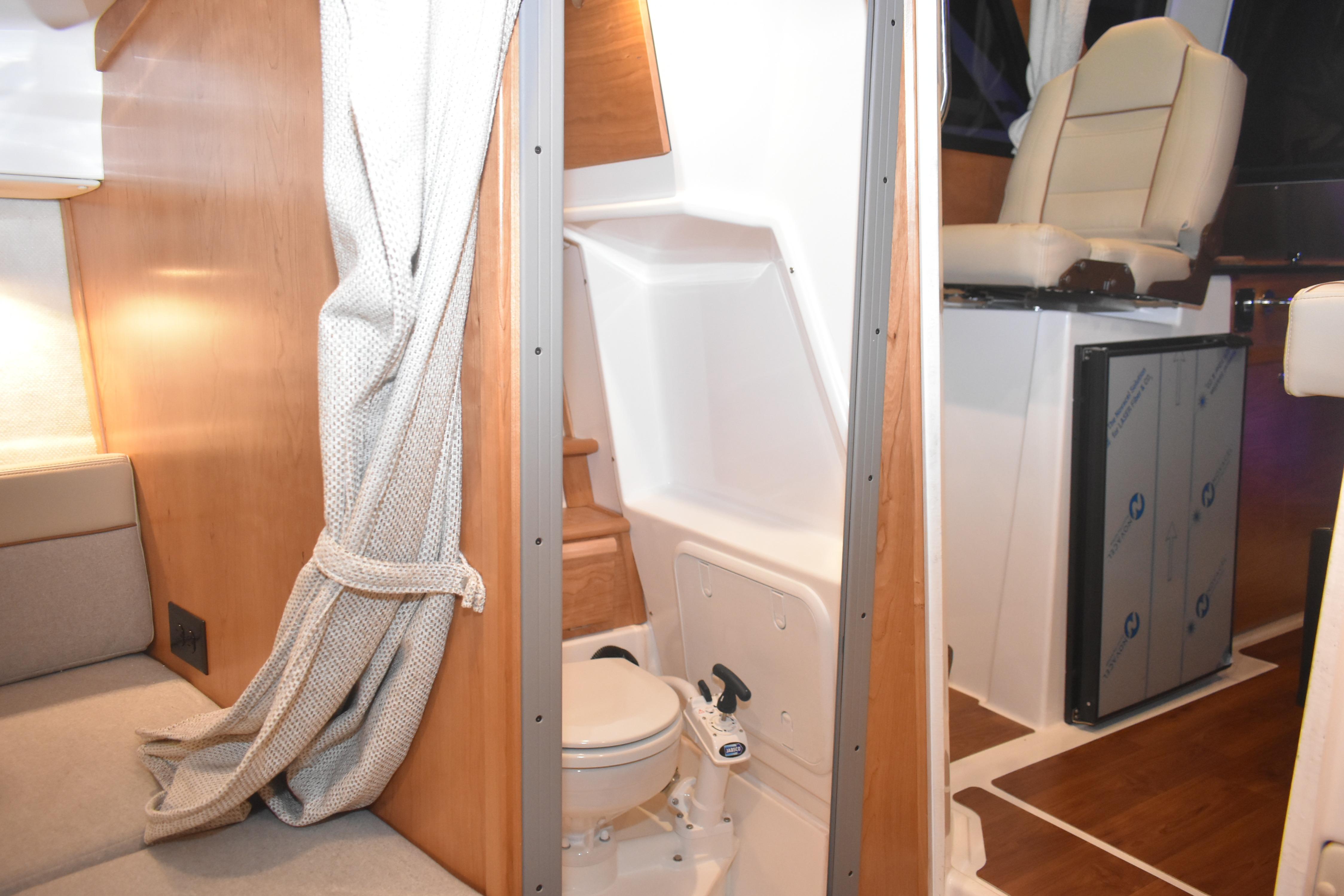 2026 Cutwater C-248 Coupe interior with compact bathroom and seating area.