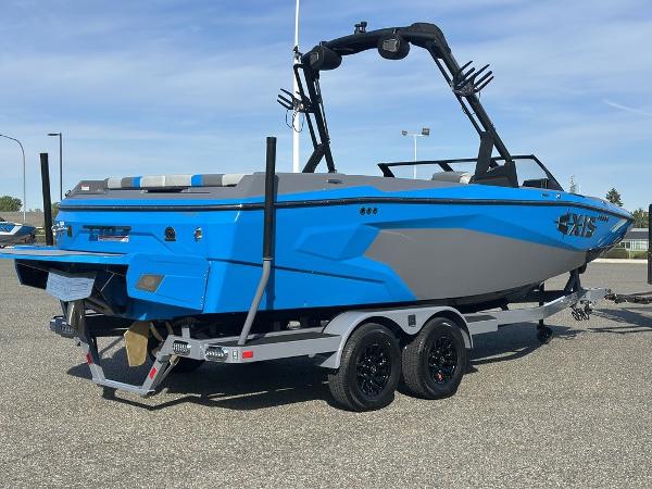 2025 Axis A225 boat in vibrant blue and gray on a trailer, parked outdoors.