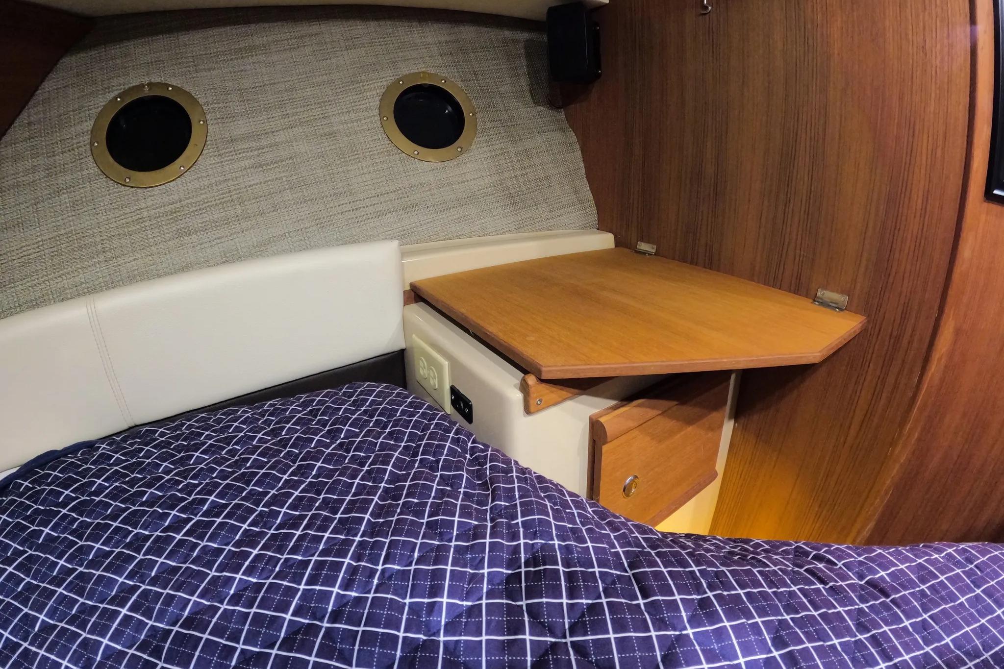 2015 Ranger Tugs R-29 S cabin interior with wooden table and portholes.