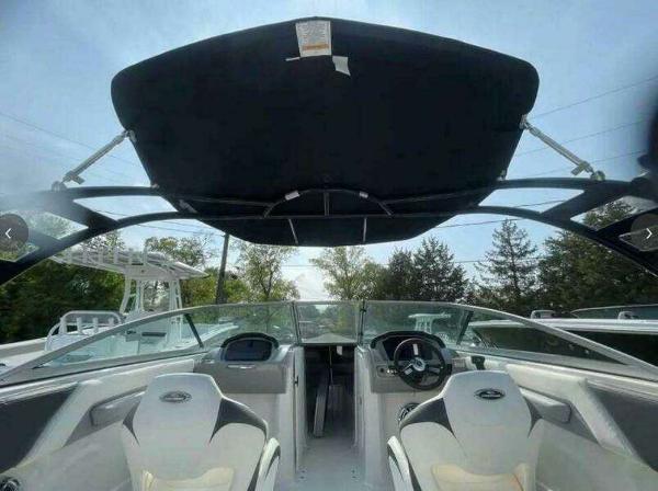 2022 Chaparral 23 Surf boat interior with canopy, featuring modern seating and dashboard.