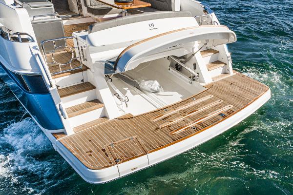 2021 Riviera 5400 Sport Yacht rear view with open storage compartment and teak swim platform.