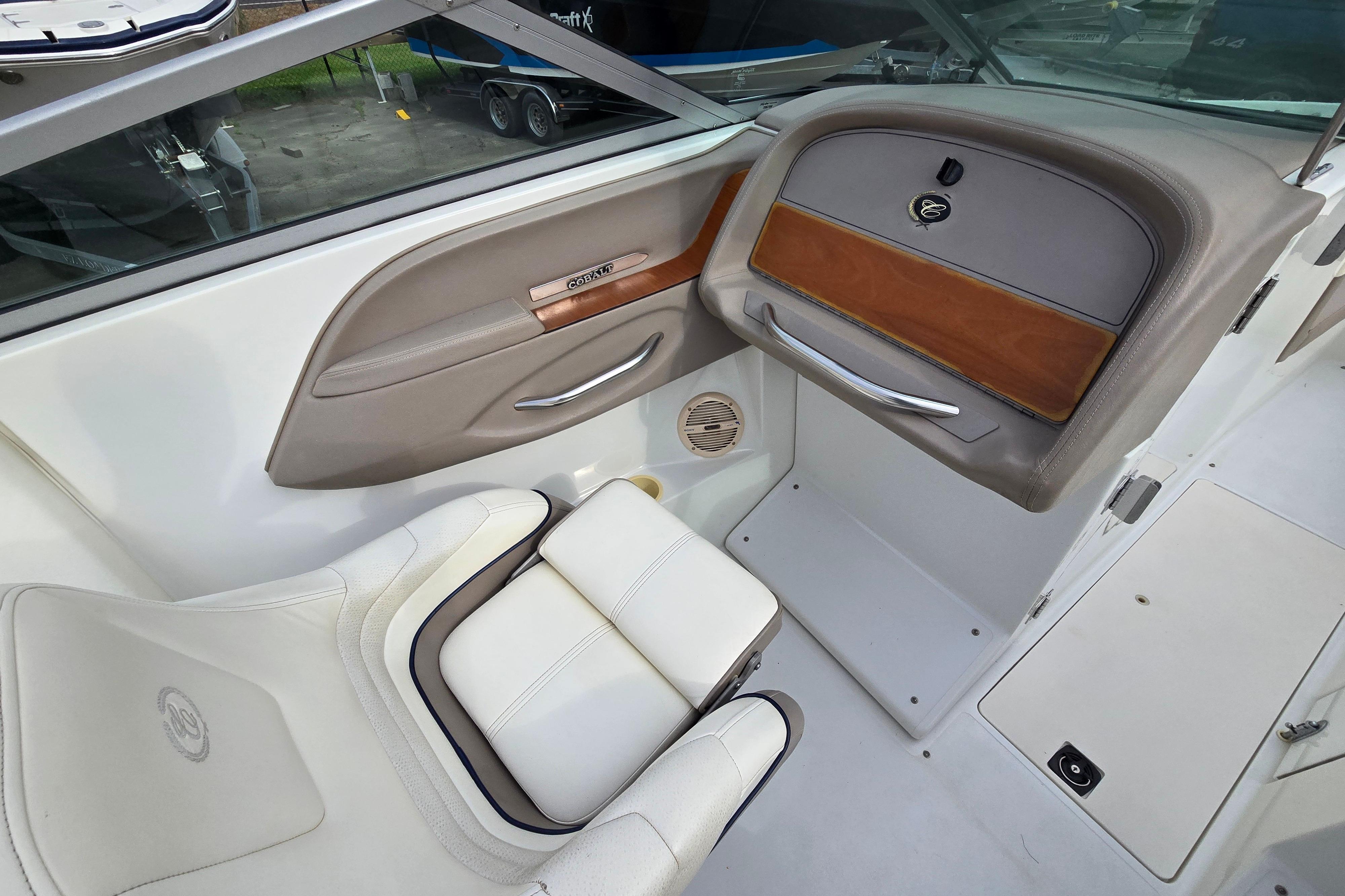 Interior of a 2000 Cobalt 246 boat, featuring white seating and sleek dashboard design.
