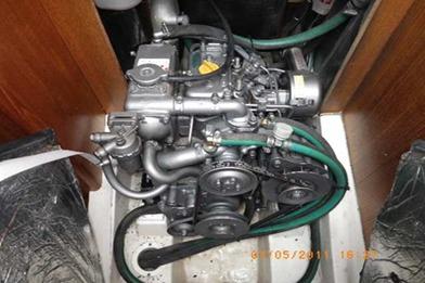 Engine compartment of a 2002 Hunter 326 sailboat, showcasing mechanical components and hoses.