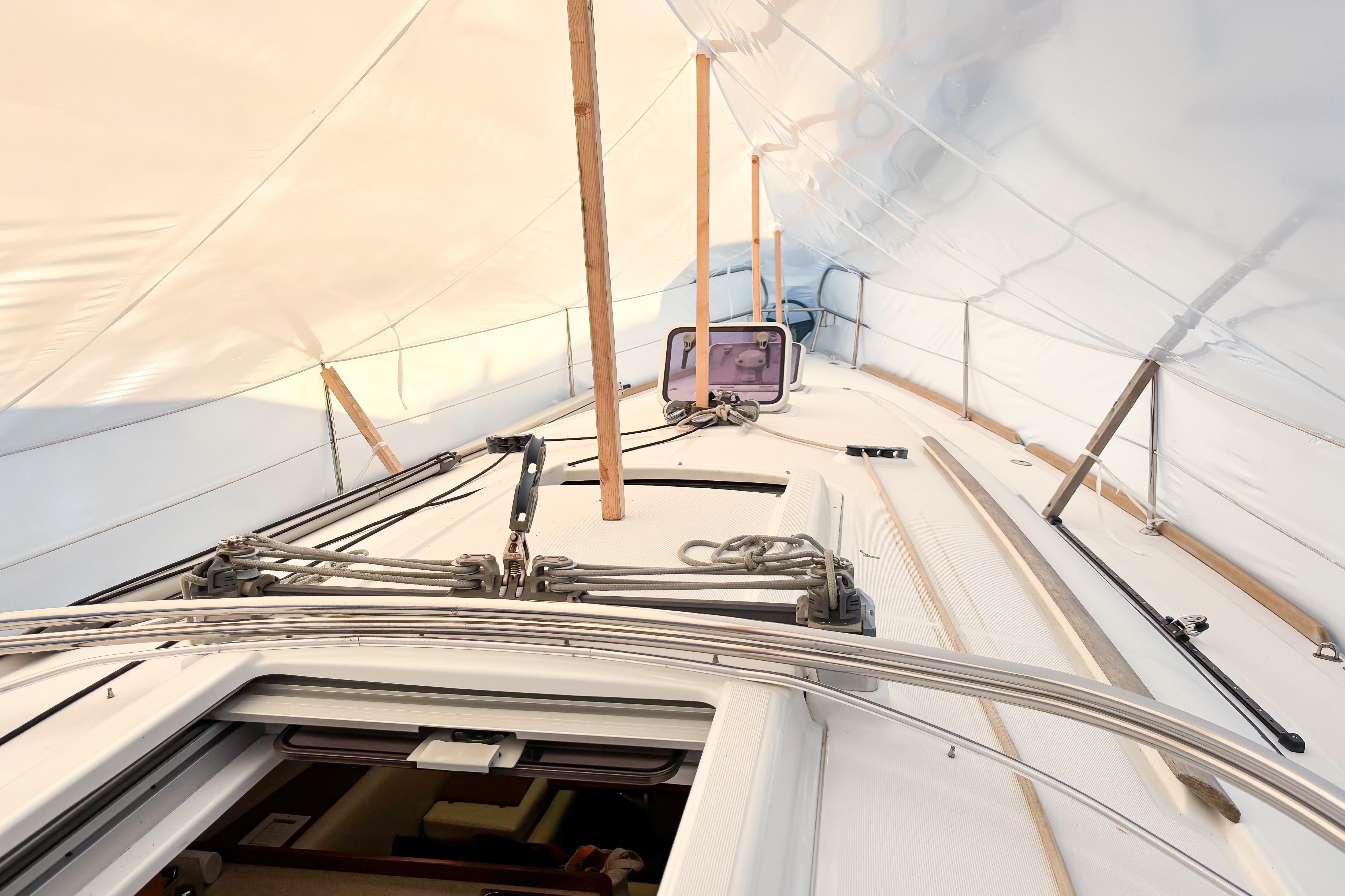 2015 Beneteau Oceanis 37 sailboat deck under protective cover, showcasing rigging and hatch.