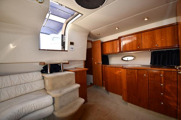 Interior of 1997 Sunseeker Camargue 47 yacht with wooden cabinets and white seating.