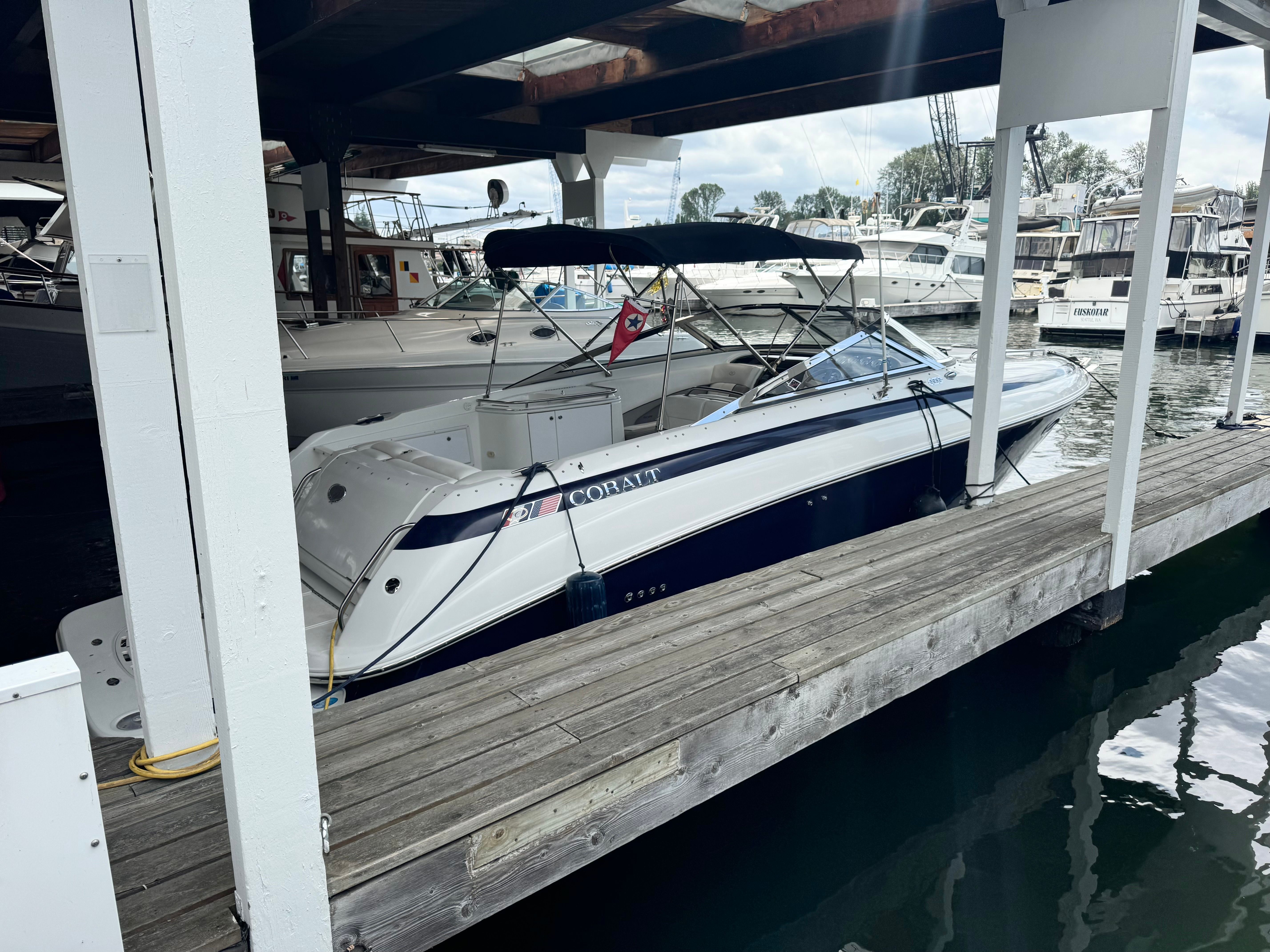 1999 Cobalt 293 boat docked under a marina.