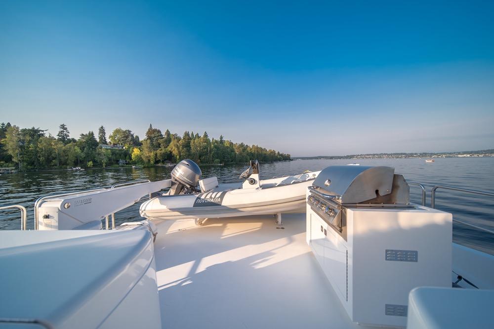 2008 Hatteras 72 Motor Yacht deck with grill and tender on calm water.