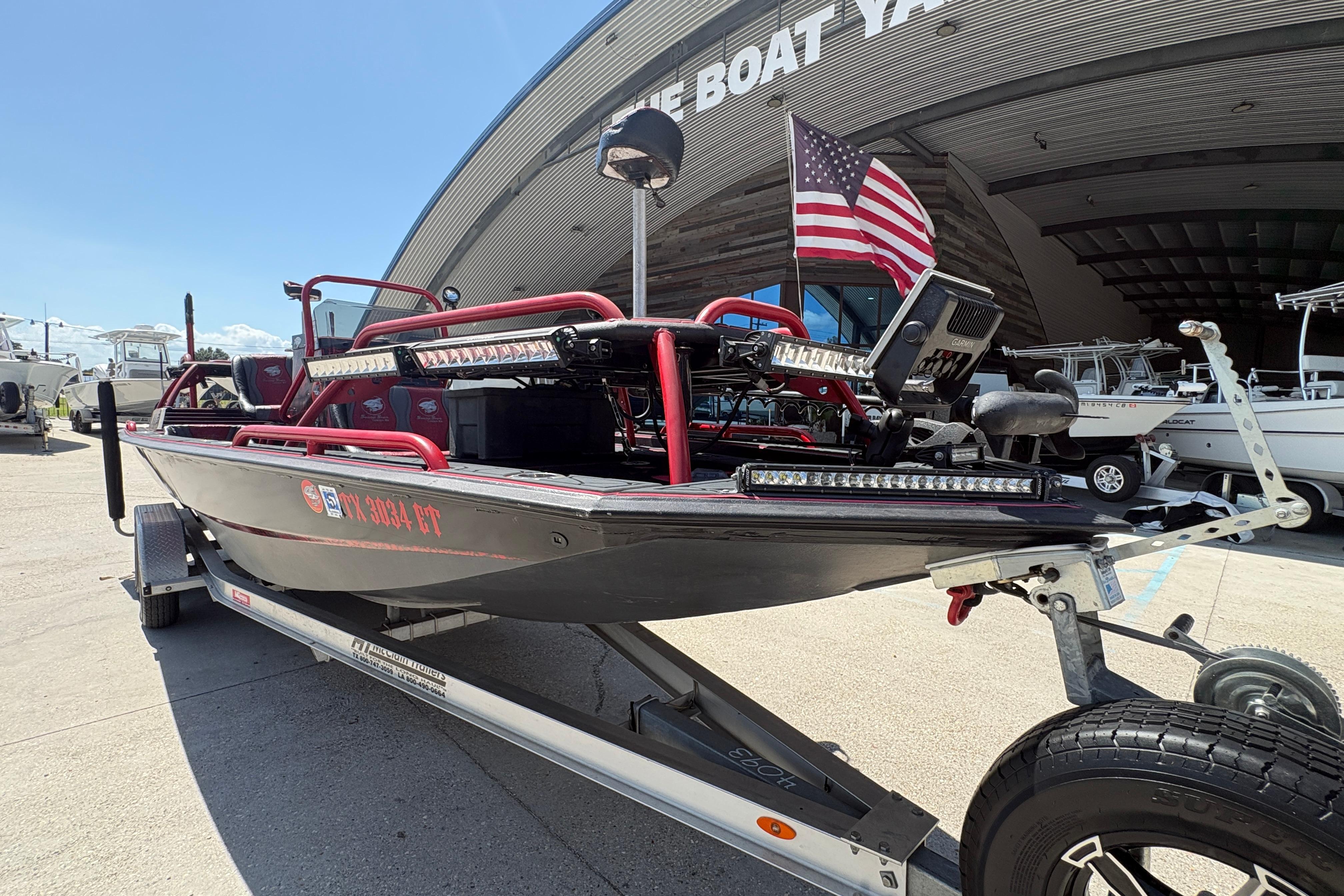 2018 Custom Swamp Shark 24' boat on trailer, American flag, outside boat yard.