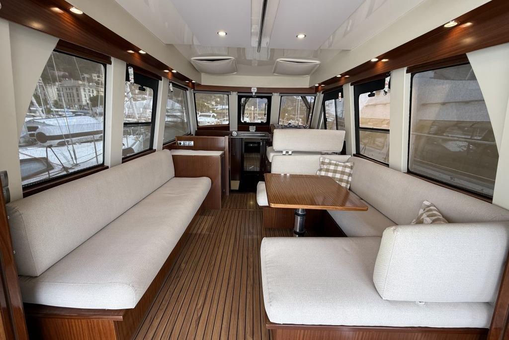 Interior of 2012 Sasga Yachts Menorquin 42 with elegant seating and wooden flooring.
