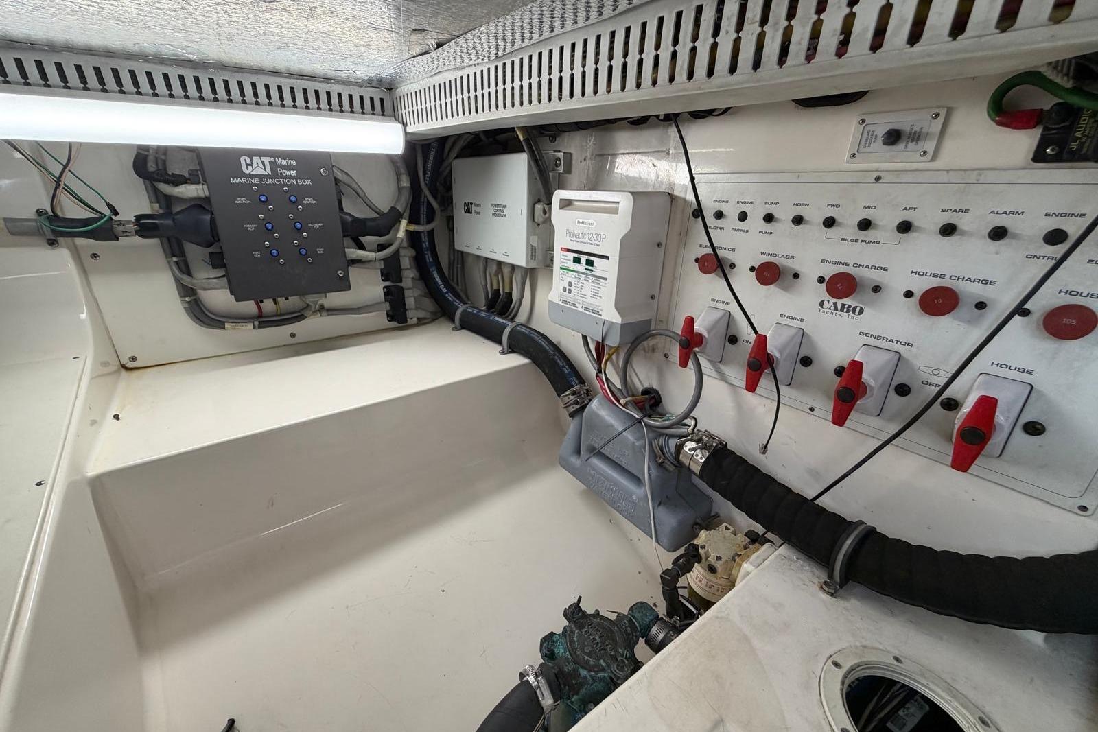 Engine room of 2004 Cabo 35 Flybridge with control panels and wiring.