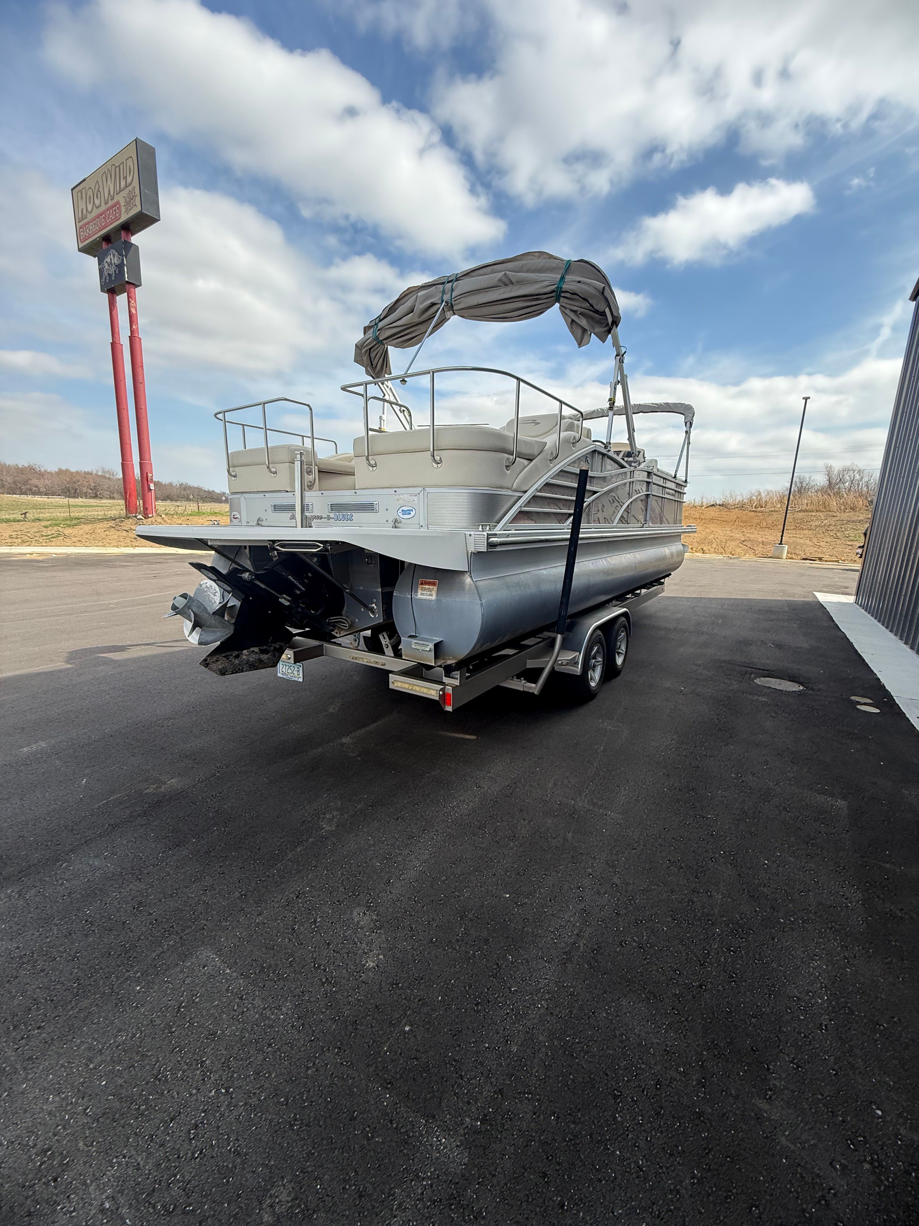2014 Bennington 2575RCW-I/O pontoon boat on trailer, cloudy sky.