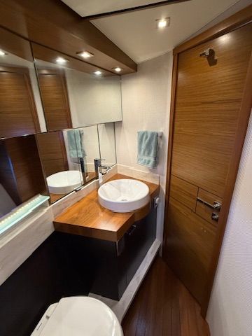 The image shows an elegant bathroom with wood paneling, a sink, and a mirror.