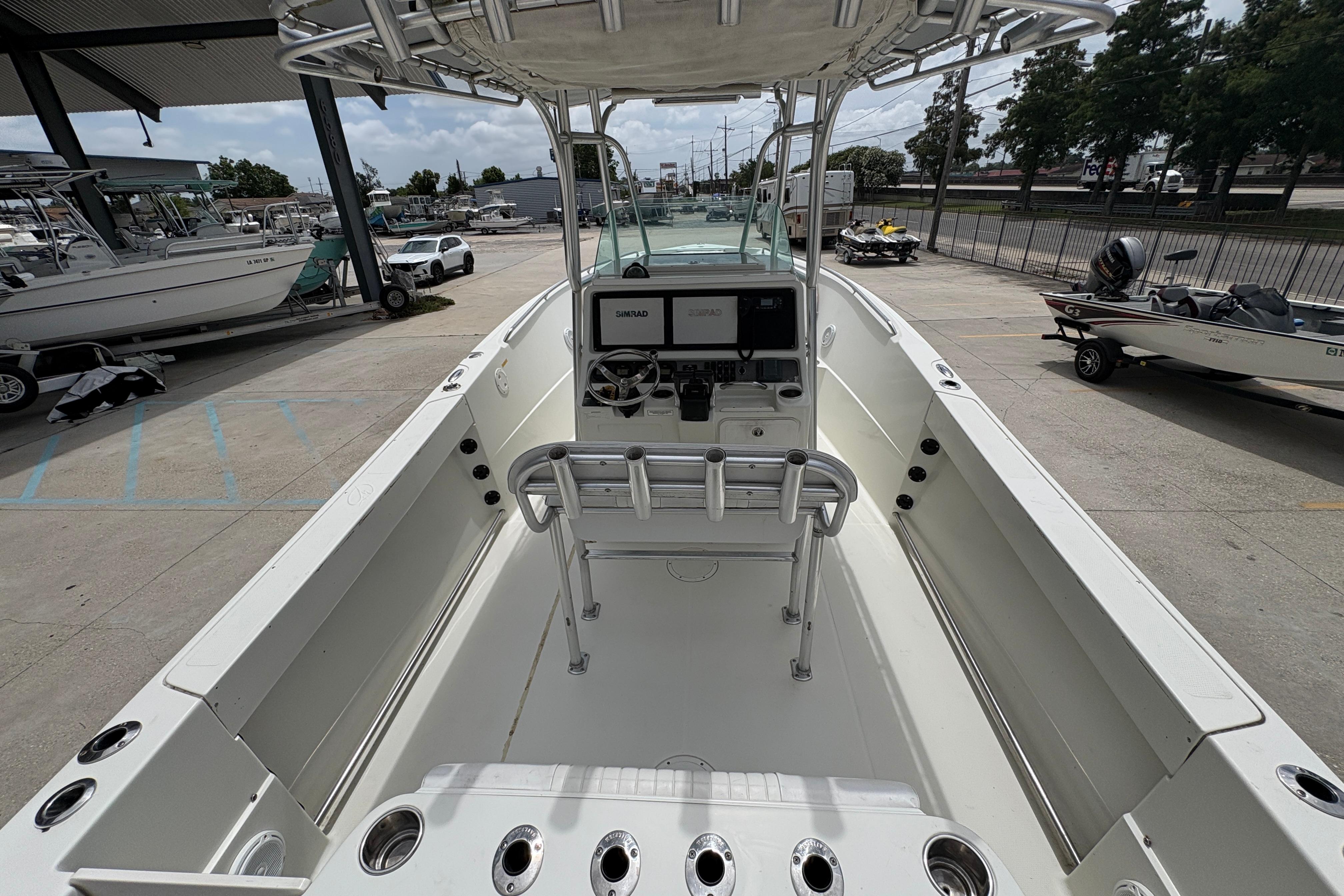 2006 Sail Faish 2360 boat interior with steering console and rod holders in a marina setting.